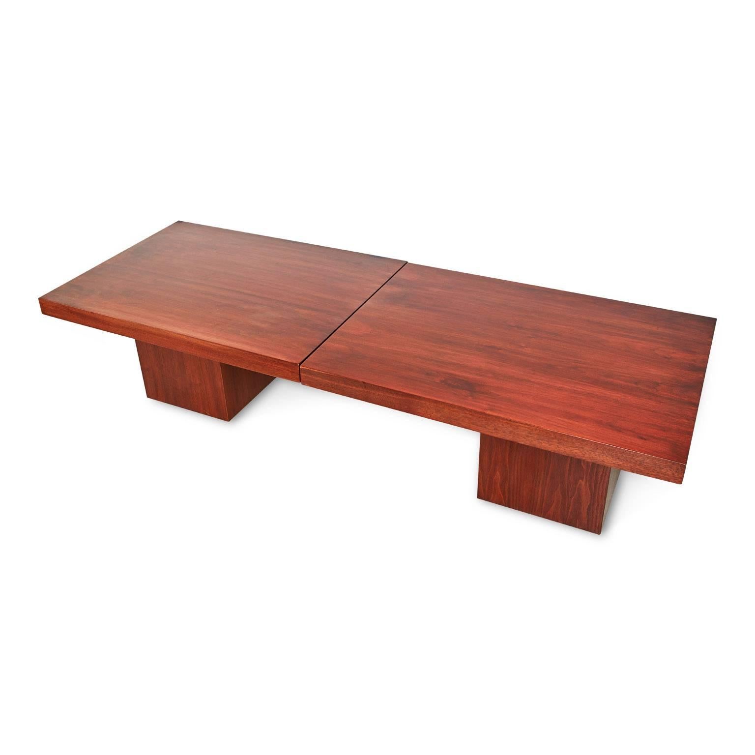 Innovative and versatile extending walnut coffee table designed by John Keal for Brown Saltman which cleverly expands to reveal a black laminate surface top, perfect to accommodate excess guests at gatherings. Fabricated from warm-hued walnut with