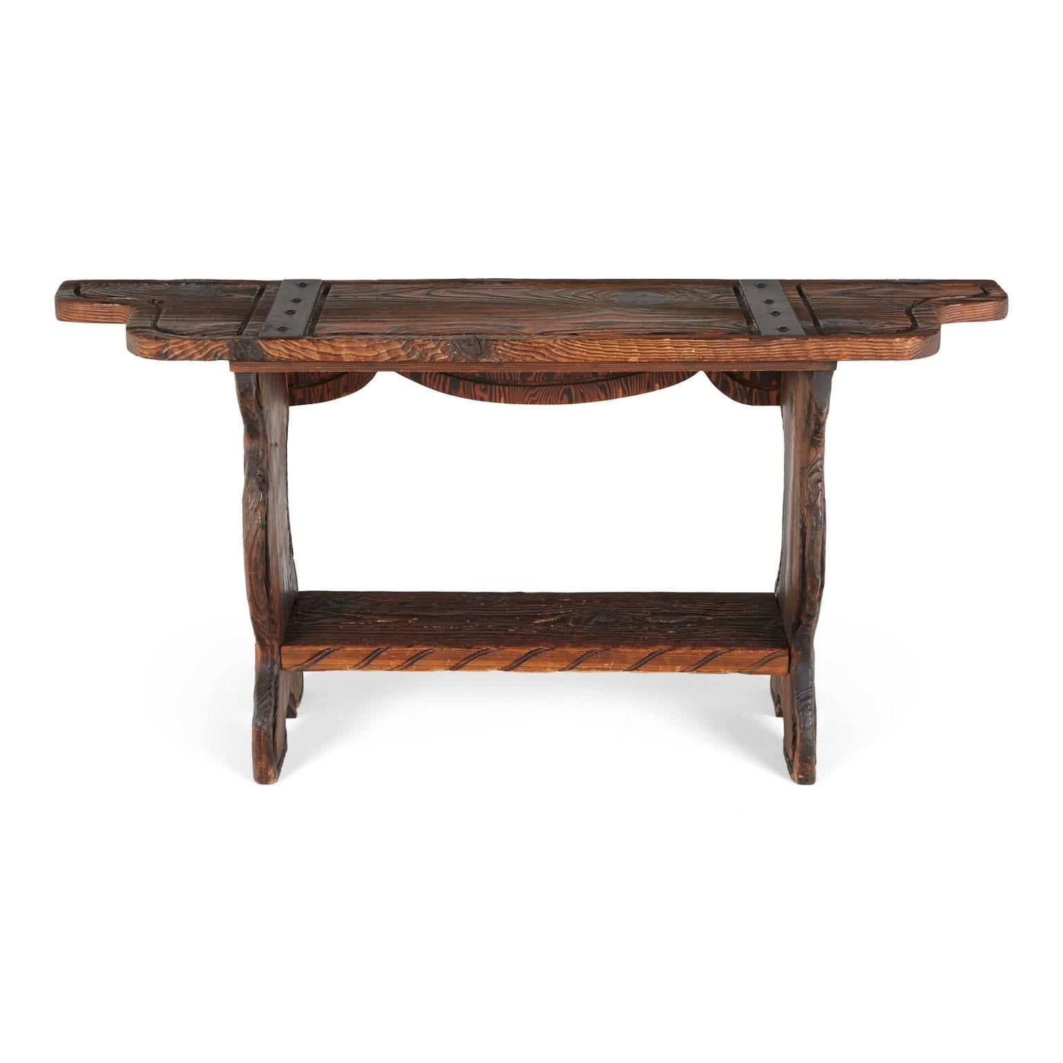 This ornately crafted red walnut console with carved exotic details is a testament to William Westenhaver's Modern Primitive creations. Influenced by Polynesian natives sculpting their ancestral deities in to wood furnishings, Westenhaver fused his
