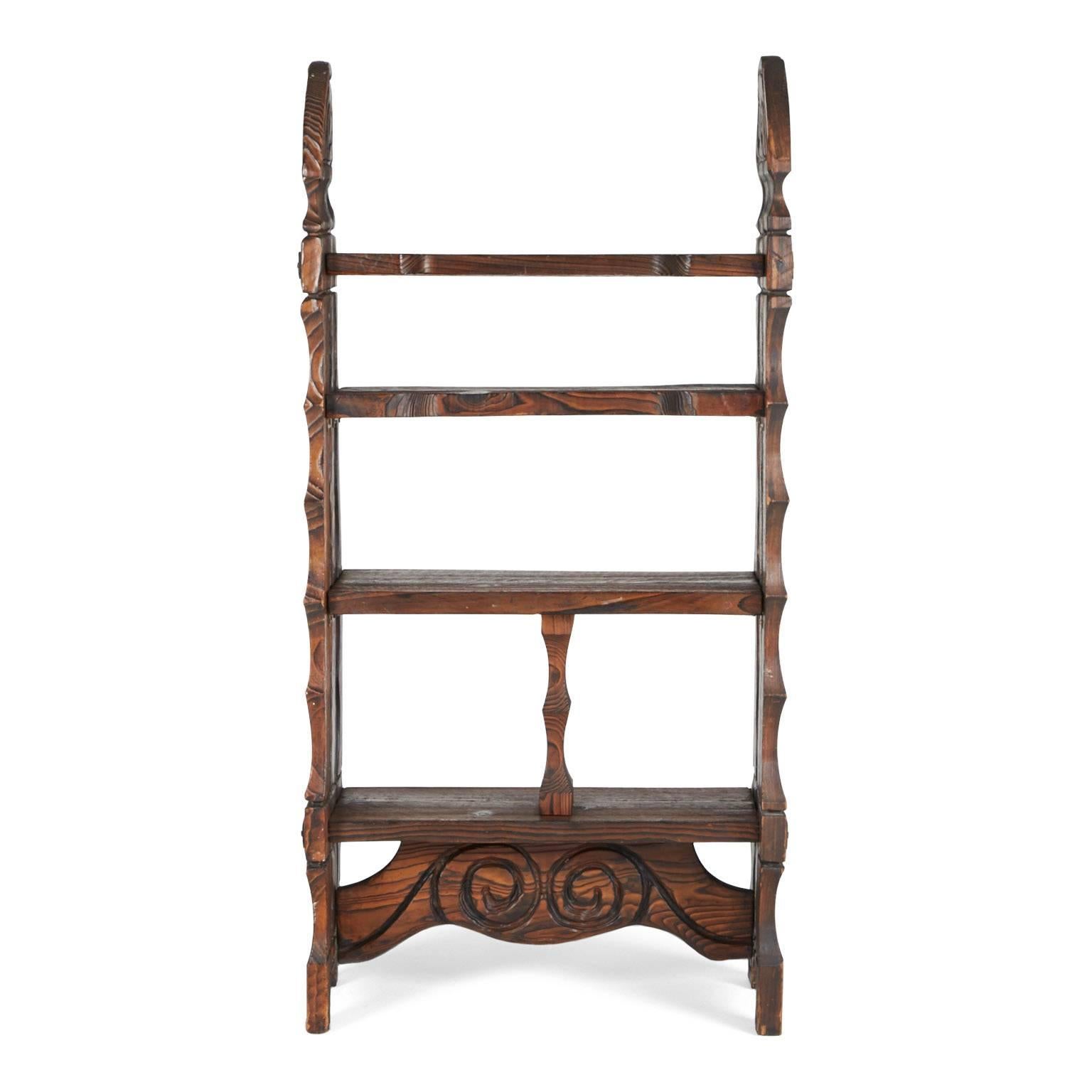 This ornately crafted red walnut étagère with carved exotic details is a testament to William Westenhaver's Modern Primitive creations. Influenced by Polynesian natives sculpting their ancestral deities in to wood furnishings, westenhaver fused his