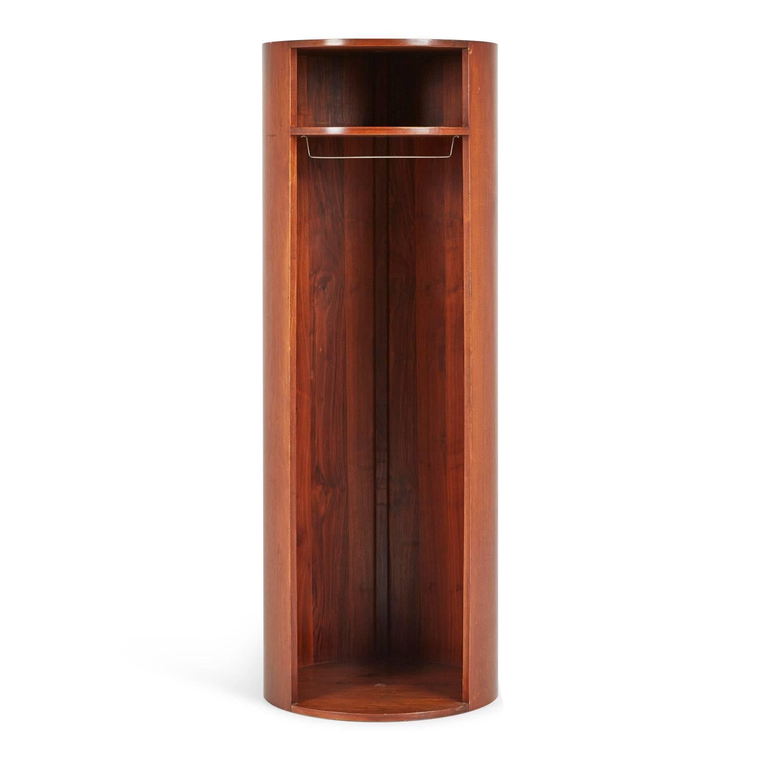 Innovative Danish modern cylindrical wardrobe manufactured by Lehigh Furniture Company. This functional and elegant piece is fabricated from solid walnut with a dark finish and the interior contains one shelf and a hanging rod. There are holes