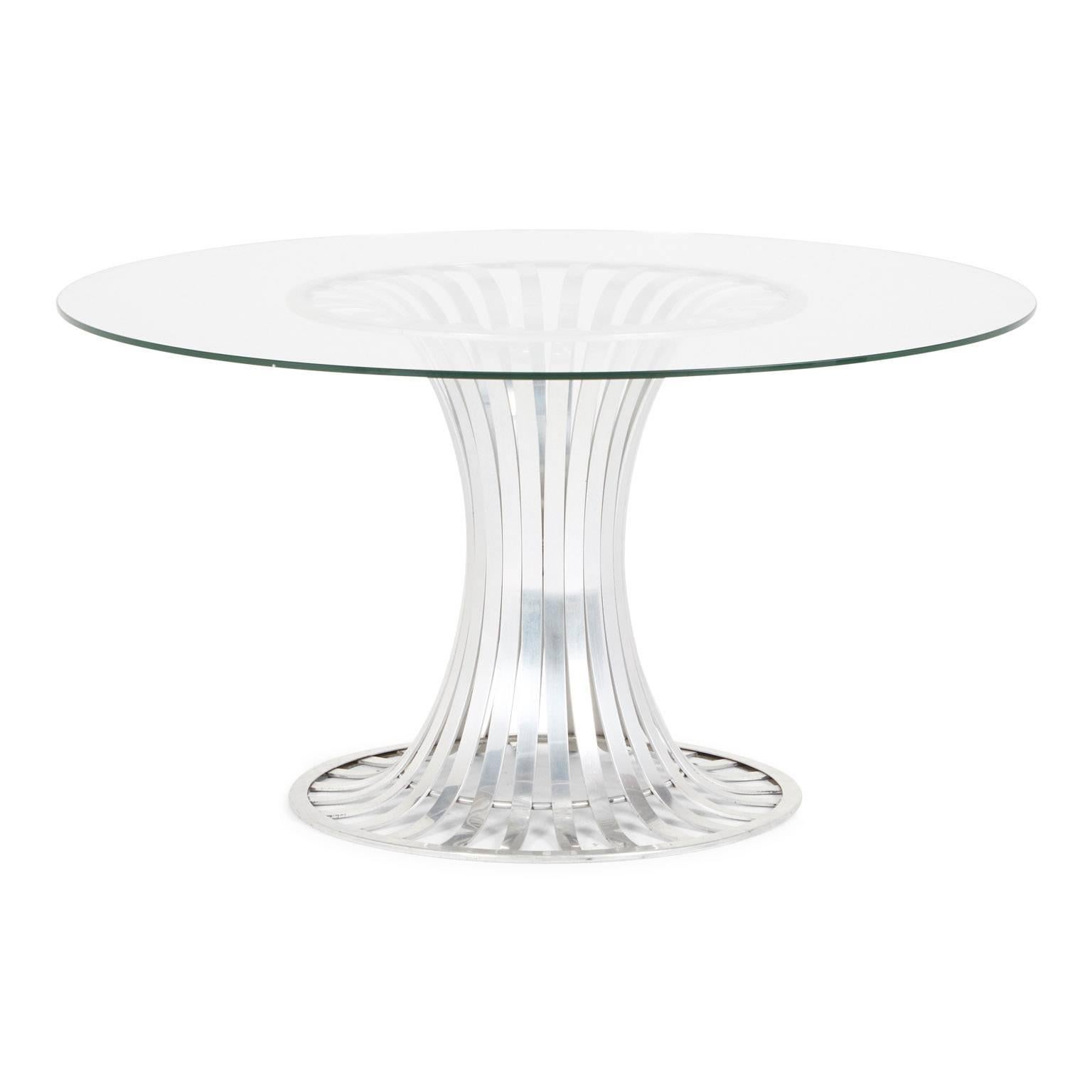 Designed by Russell Woodard and produced in the early 1960s by the Woodard Furniture Company, this sleek aluminium dining table with glass top can be used indoors or out.

The current glass top is 42