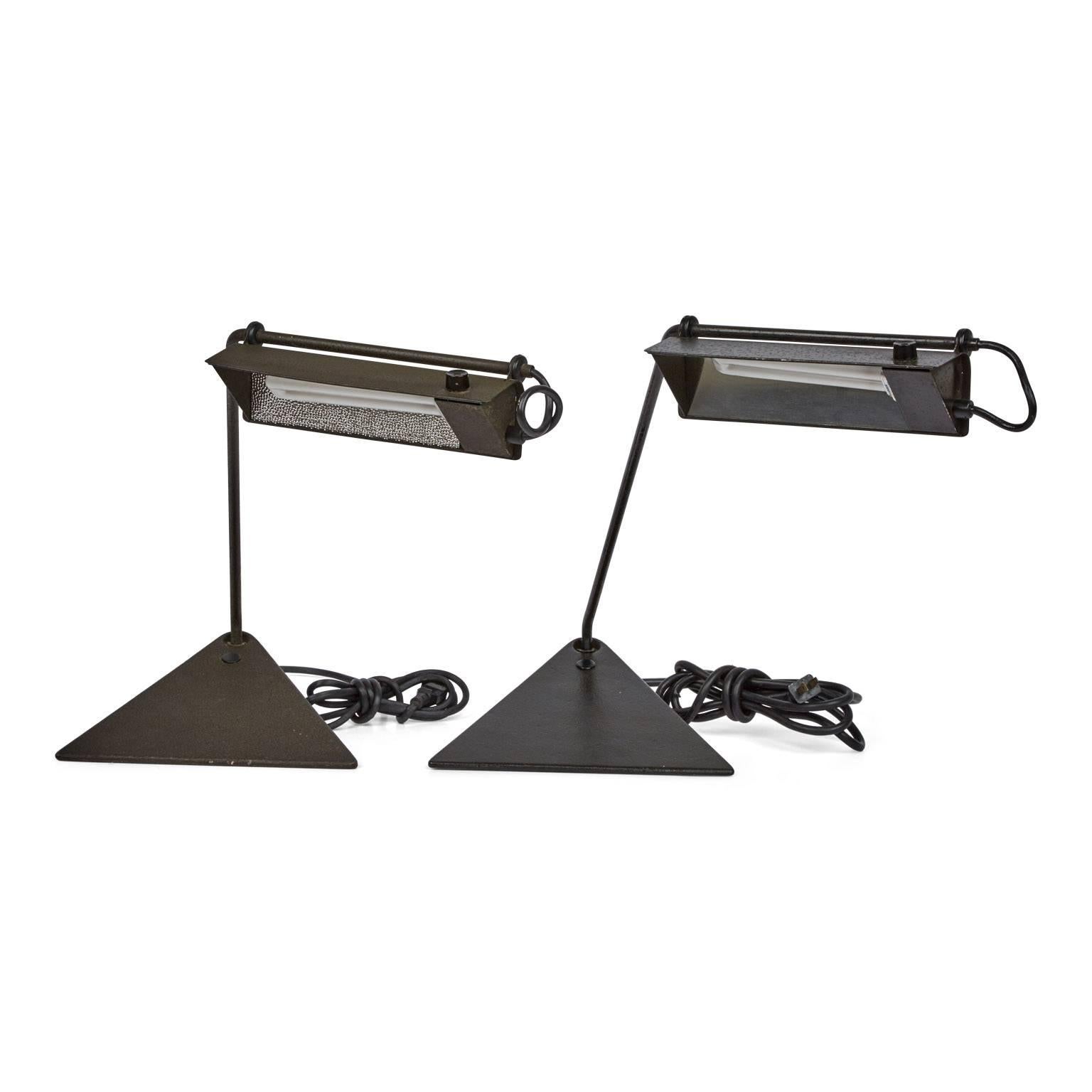 Pair of enameled metal desk lamps by Koch & Lowy. These sculptural lamps feature articulating shades with thumb wheel switch and swivel from the base, allowing for adjustable and focused lighting. The robust enameled metal which these lamps are