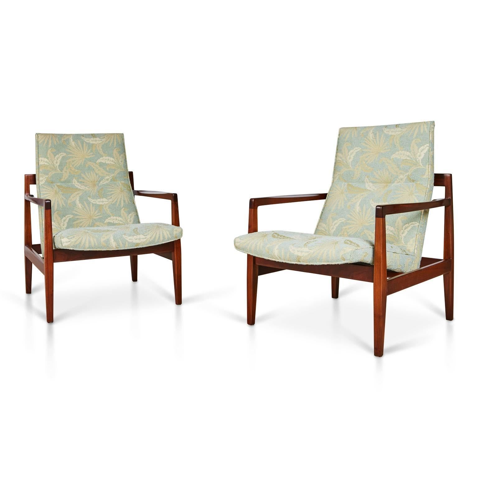 Danish born Risom introduced his trademark designs of simple, well-crafted modern furniture to America, this pair of lounge chairs being a testament of those principals. 

This pair of floating walnut framed lounge chairs have been newly