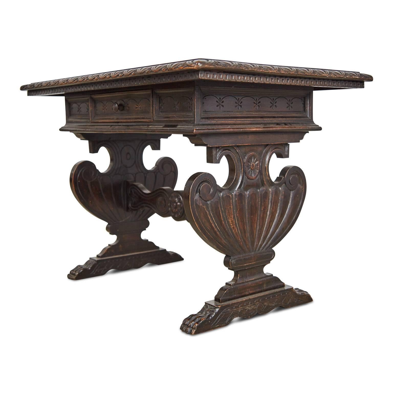 Solid walnut Renaissance Revival trestle table from the mid-19th century. Comprising of a rectangular top with carved egg and dart edge above a single drawer, with trestle supports in the form of Tuscan vases and a detailed stretcher uniting them