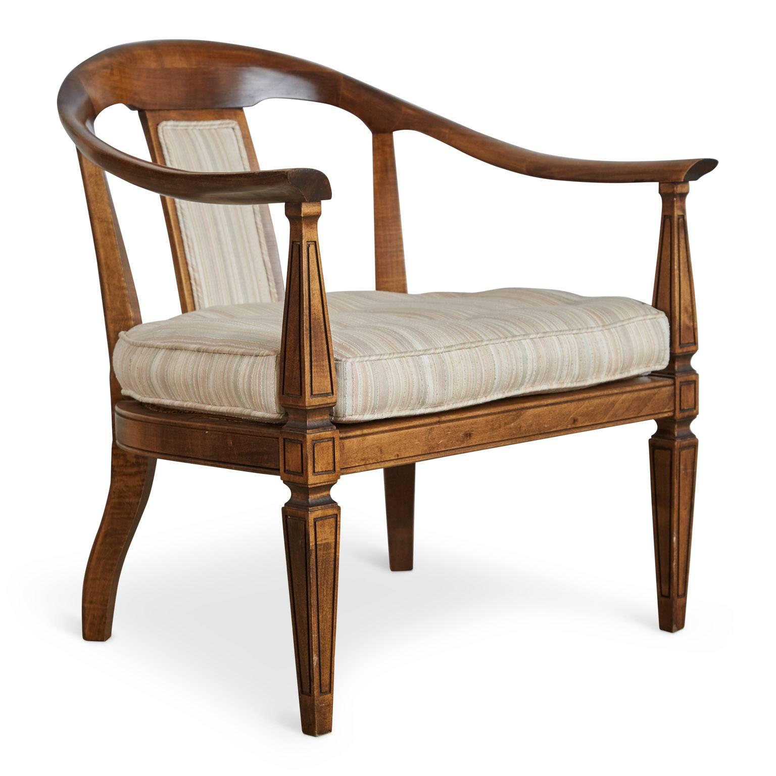 Gracefully curved pair of two armchairs. The frame is fabricated from walnut with beautiful curved backs, armrests, flared handholds and fluted legs. The seats feature woven caning which can be found by lifting the removable button tufted box edge