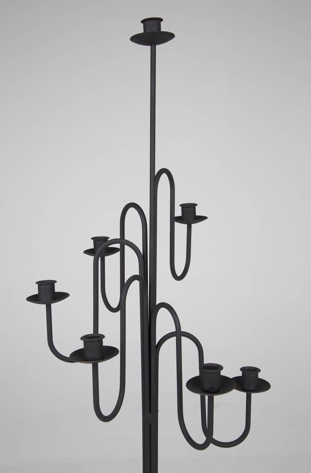 Tall and statuesque Erik Hoglund or Tommi Parzinger style standing candelabra. Fabricated from wrought iron that undulates gracefully to allow for six (6) candles at various heights and one further candle at the pinnacle.

This elegant Stand would