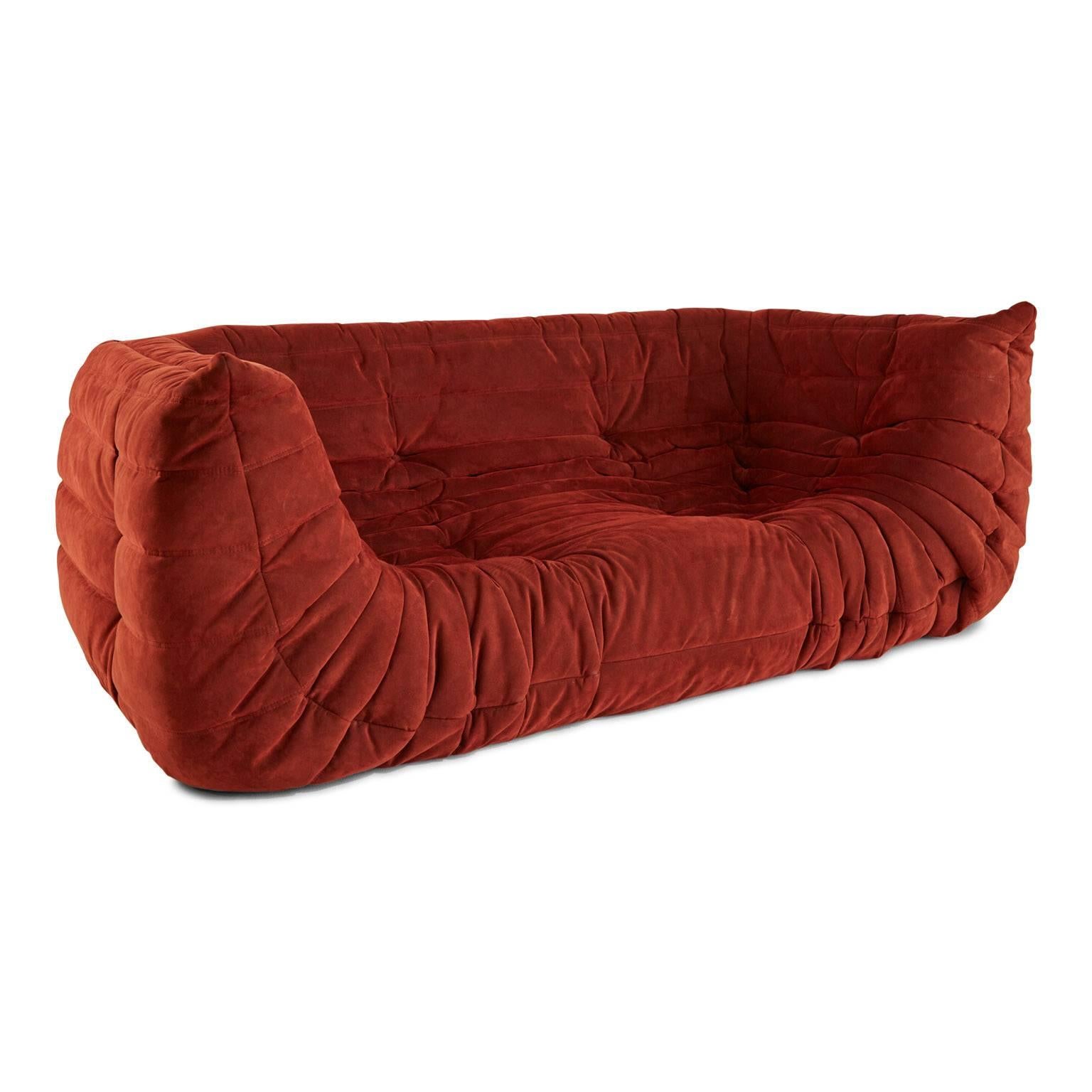 Timeless Ligne Roset Togo settee sofa designed by Michel Ducaroy in 1973. This sofa features ergonomic design with multiple density foam construction and generously quilted cover which are in Ligne Roset's Red Alcantara colorway. 

This iconic
