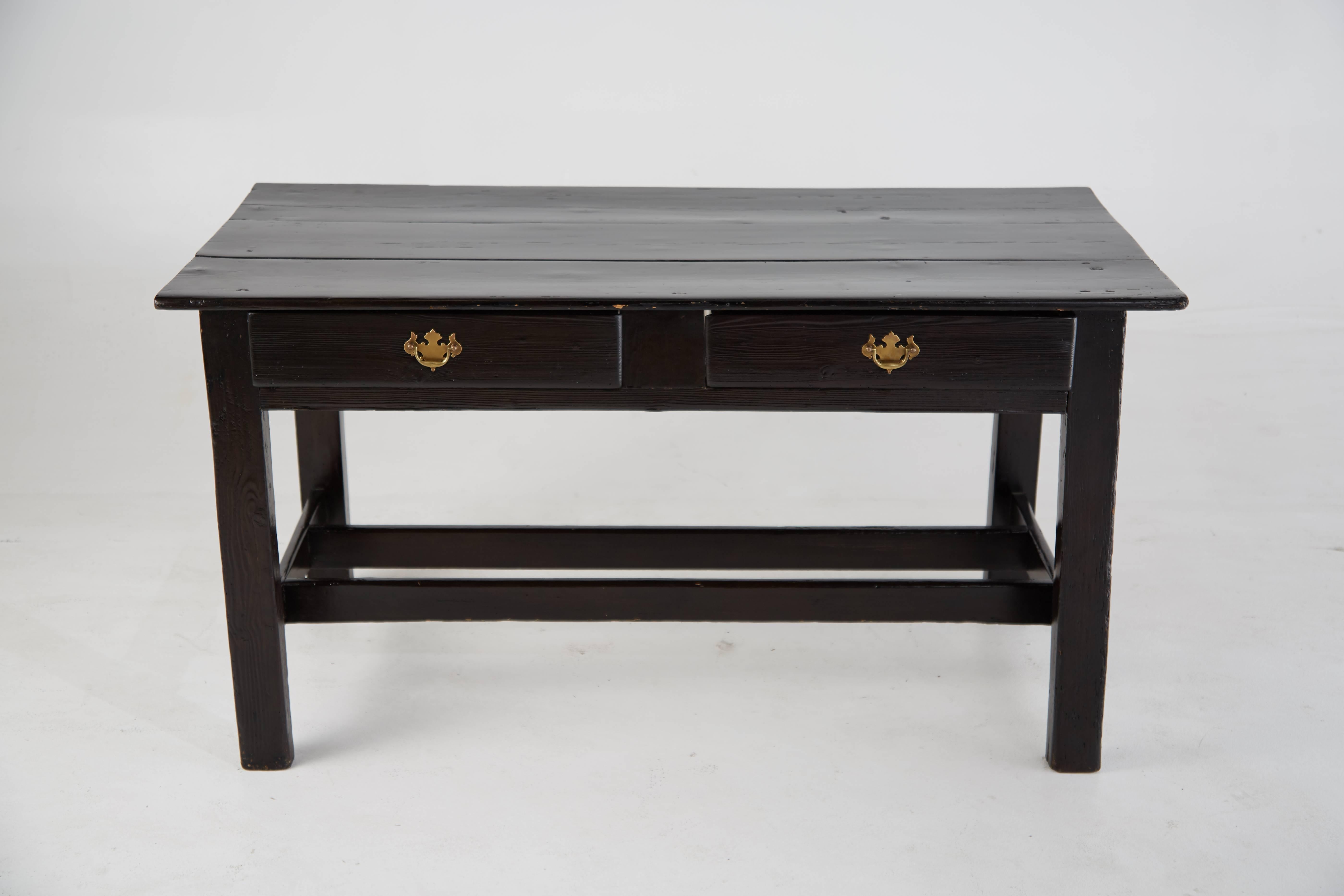 Sleek and simplistic black lacquered vintage wooden desk with brass ornate handle pulls. This desk features two pull-out drawers at the front and stretchers running along each side.

The clean lines and compact design would allow this desk to fit