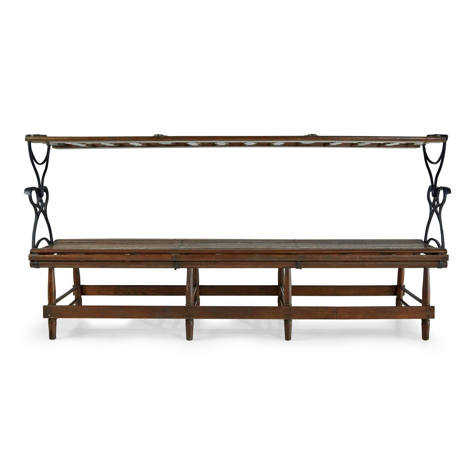 Add some industrial style to your interior or exterior design concept with this Victorian iron and wood reversible railroad bench. This Machine Age piece features a rotating mechanism that allows the spindled back of this bench to be switched from