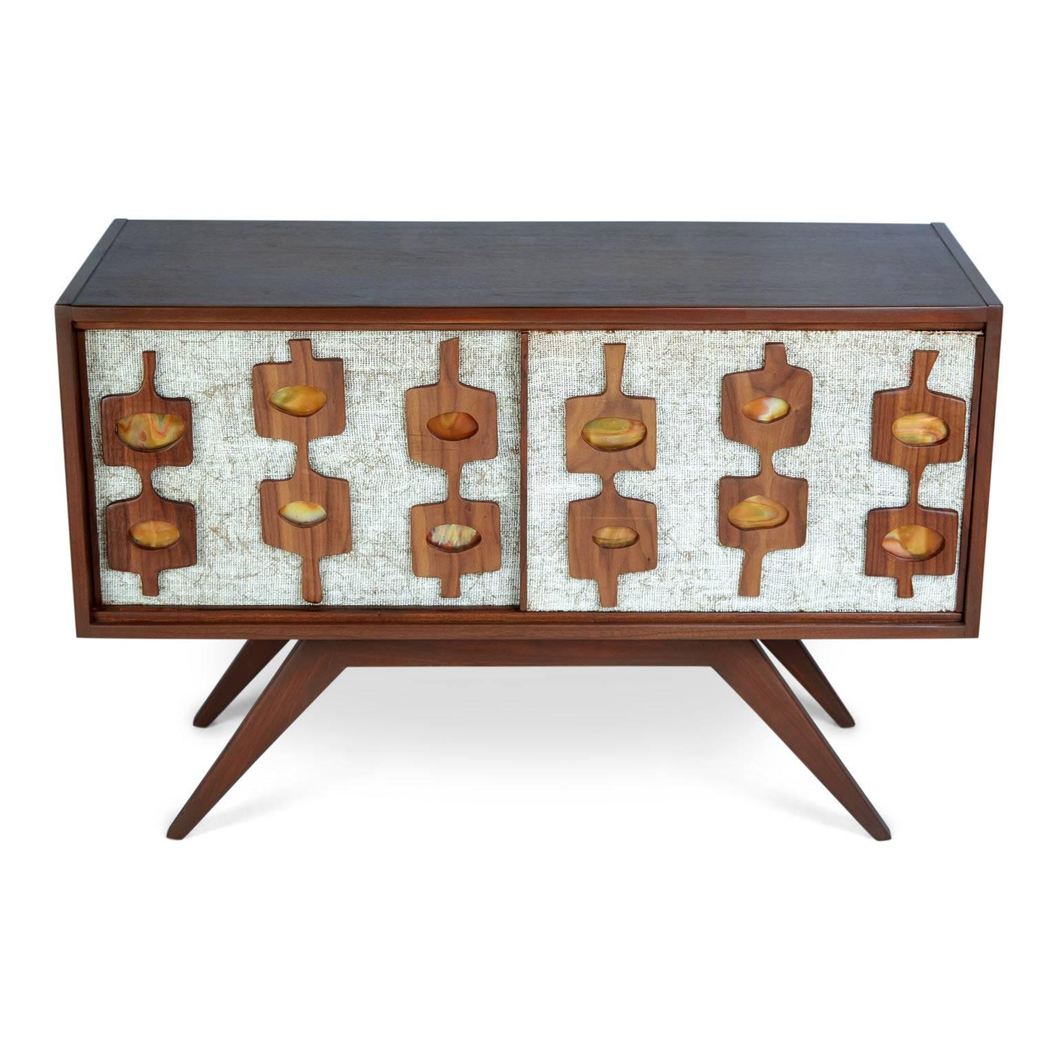 A custom-made credenza crafted by local Los Angeles artisan Lou Ramirez. This petite proportioned credenza is illustrative of the Mid-Century Modern movement with a nod to the short lived Googie design era that was uniquely Los Angeles.

Featuring