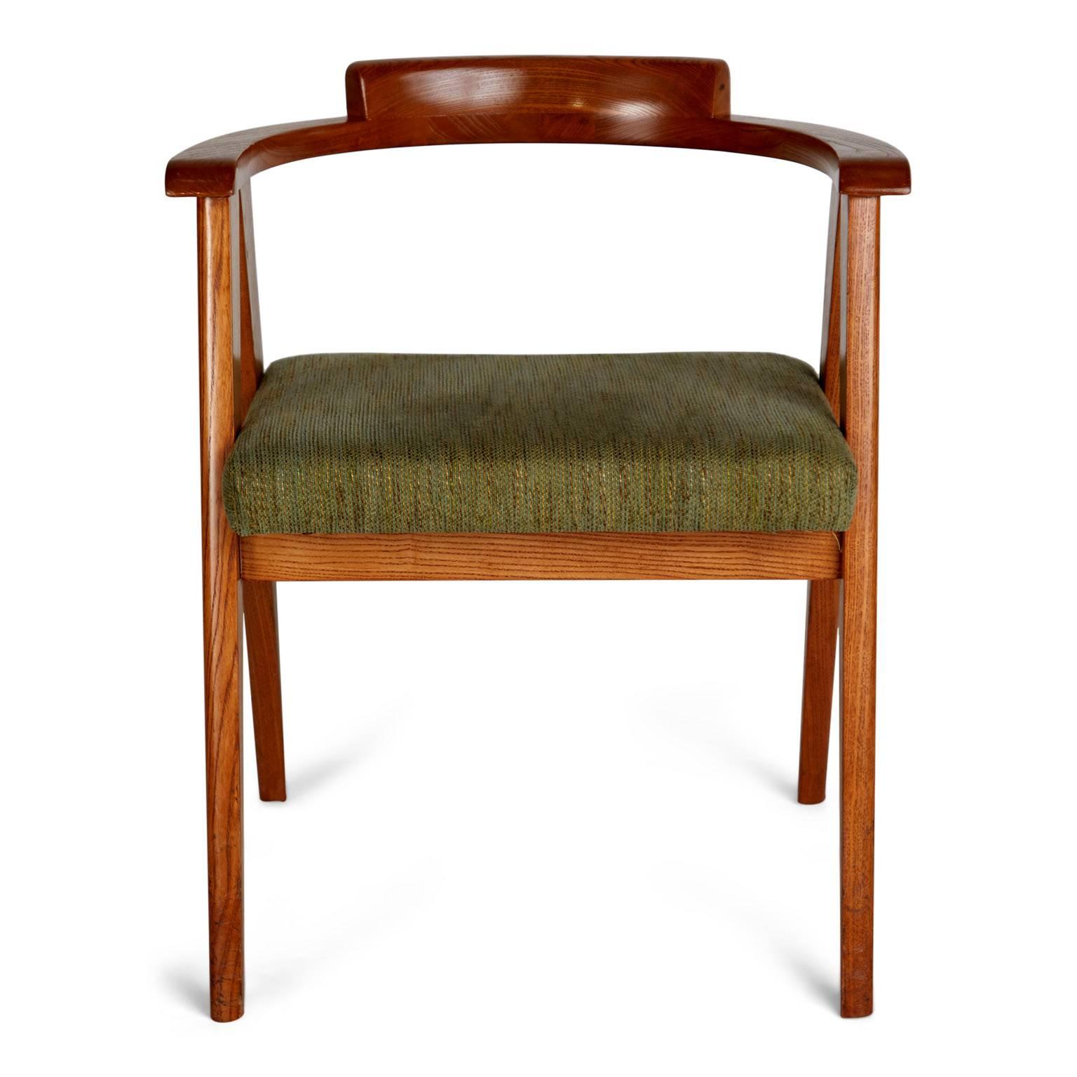 Sleekly designed chairs in the style of James Mont. These oak dining or side chairs feature sculptural a-frame legs with rounded backs and original vintage sage green upholstery which is mixed in with striped threads of citrine, burgundy seafoam and