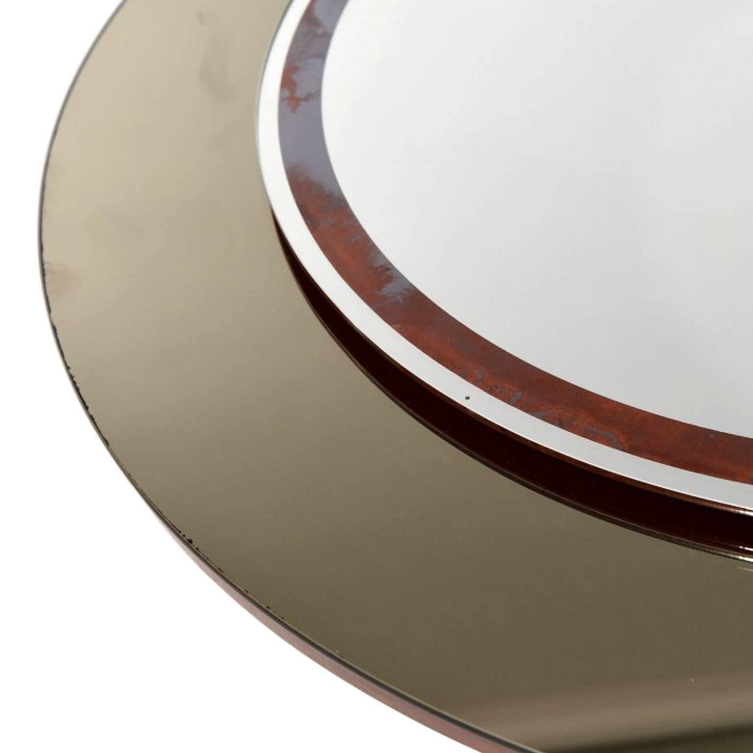 Elegant circular mirror with smoked glass rim. Layered on top is a contrast circular piece of plain mirror with a rust colored band. These pieces are mounted on to a board with a hook at the back for hanging the mirror to the wall. 

This cool and