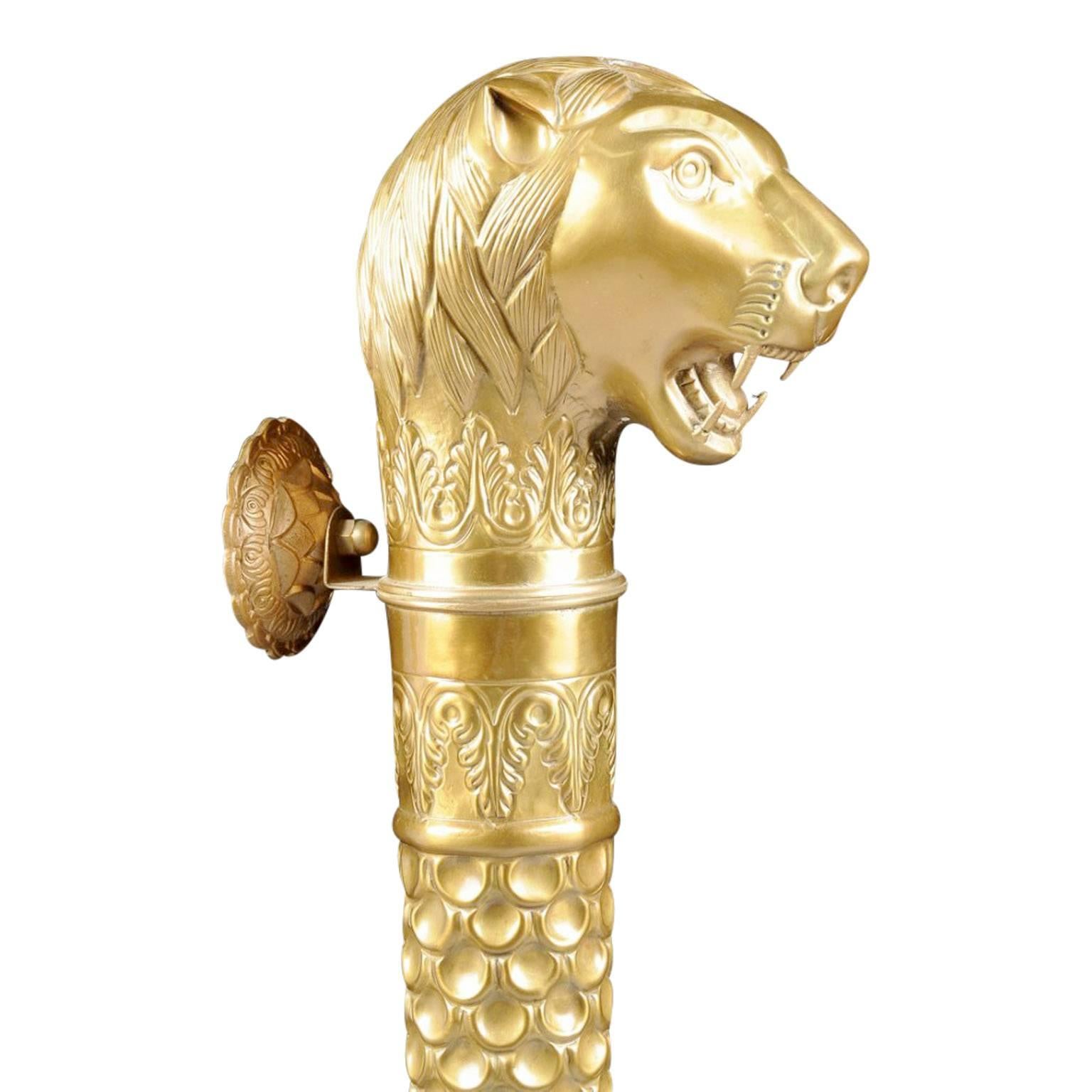 Large and majestic repoussé brass lion head door handle in the Mughal style. Consisting of a tapered circular form with a proud roaring lion's head finial which is set above scrolling leaf banding followed by sectioned panels comprised of circular