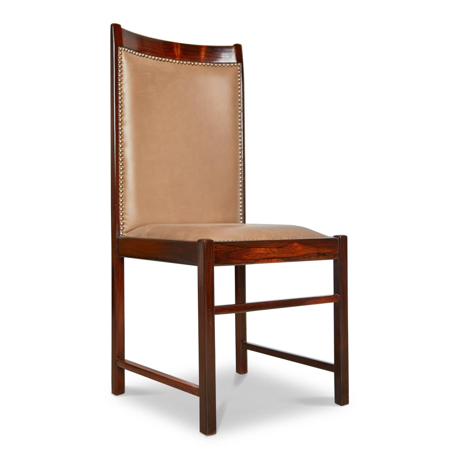 Single high back chair by Celina Moveis fabricated from solid rosewood and upholstered in a quality supple tan leather finished with bronze nailhead details. It should be noted that these chairs are handmade and therefore there may be a slight