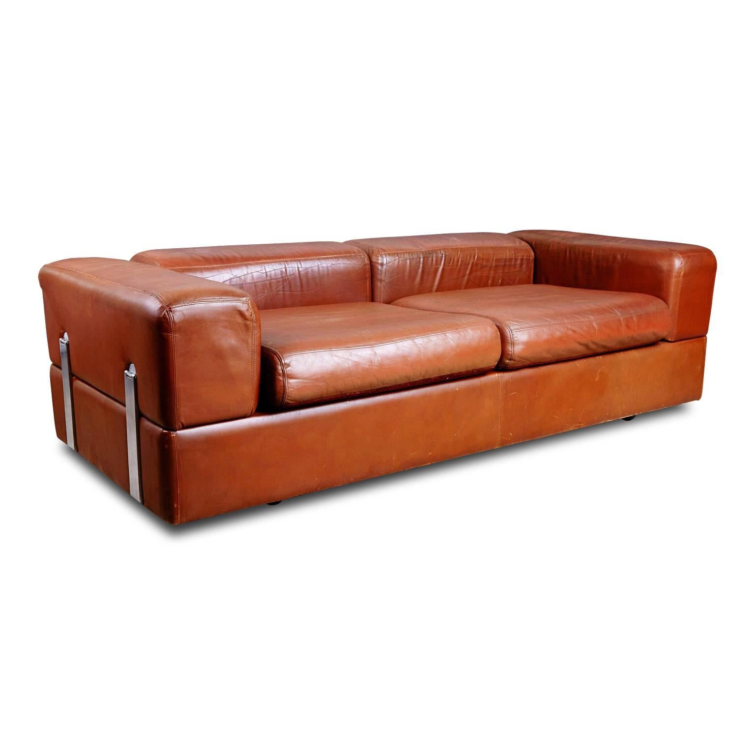 Sumptuous leather sofa that conveniently converts to bed with side tables by Italian designer Tito Agnoli for Stendig. This neat design transforms from a comfortable couch into a bed by pushing down the arm and the backrests. When these are flipped