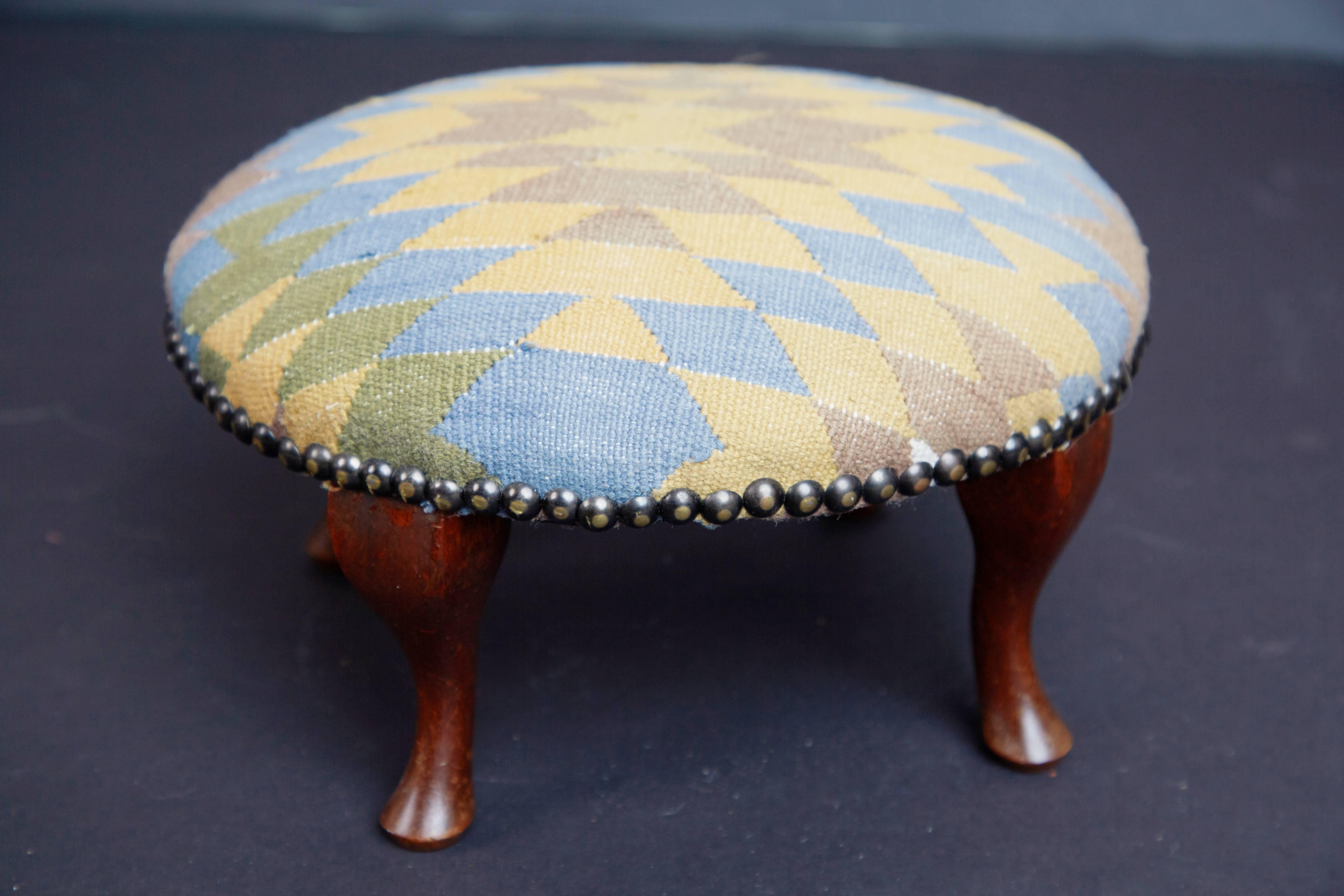 Beautifully restored petite Victorian footstool or ottoman that has been recently reupholstered by using an on trend vintage Moroccan Kilim rug. The subtly curved walnut legs have been refinished in a rich dark stain and the rug upholstery is