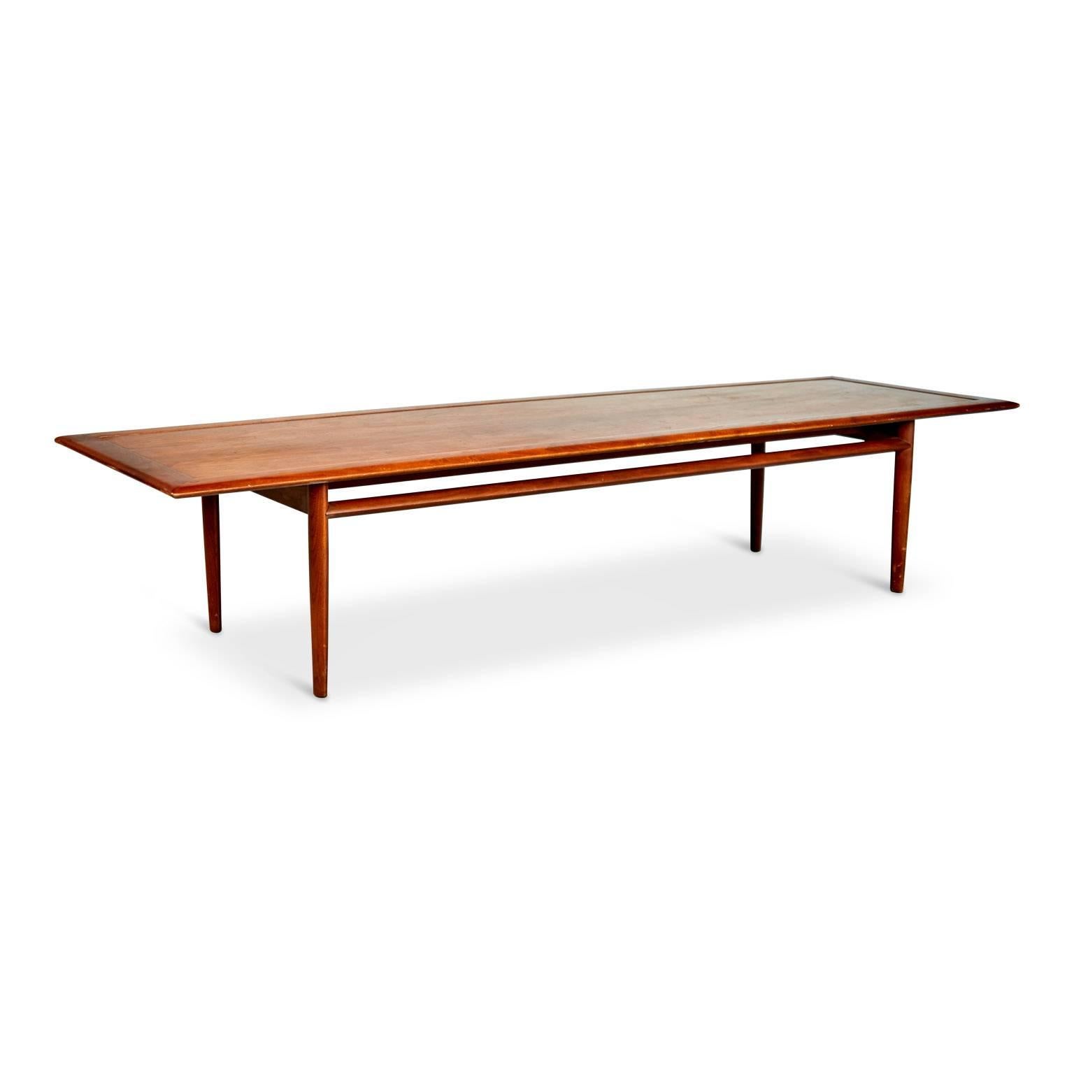 Sleekly designed Danish modern style coffee table by Kipp Stewart for Drexel. This elegantly executed cocktail table circa 1960s is fabricated from walnut with an attractive grain and features contrasting butterfly inlay details to corners. The