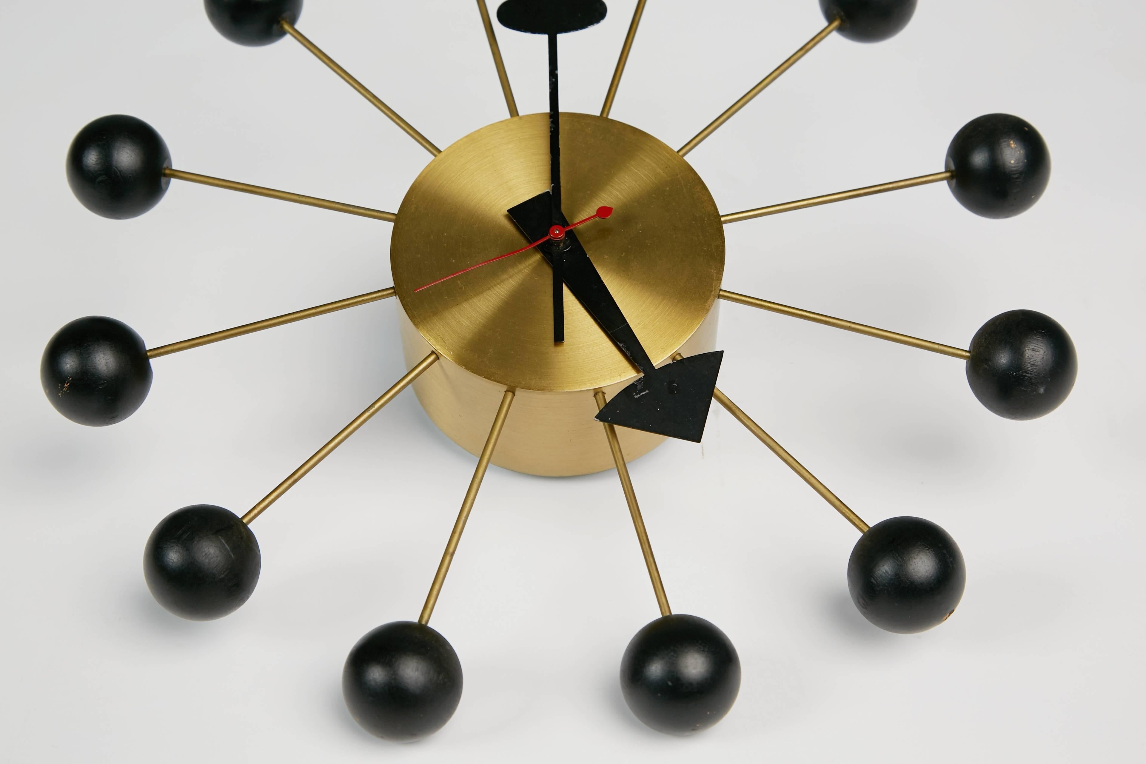 Classic vintage Ball Clock designed by George Nelson and Irving Harper for Howard Miller. The Ball Clock, first produced in 1949, is a fun and eye catching wall adornment which will add a bit of interest to any space. Featuring a brushed brass base