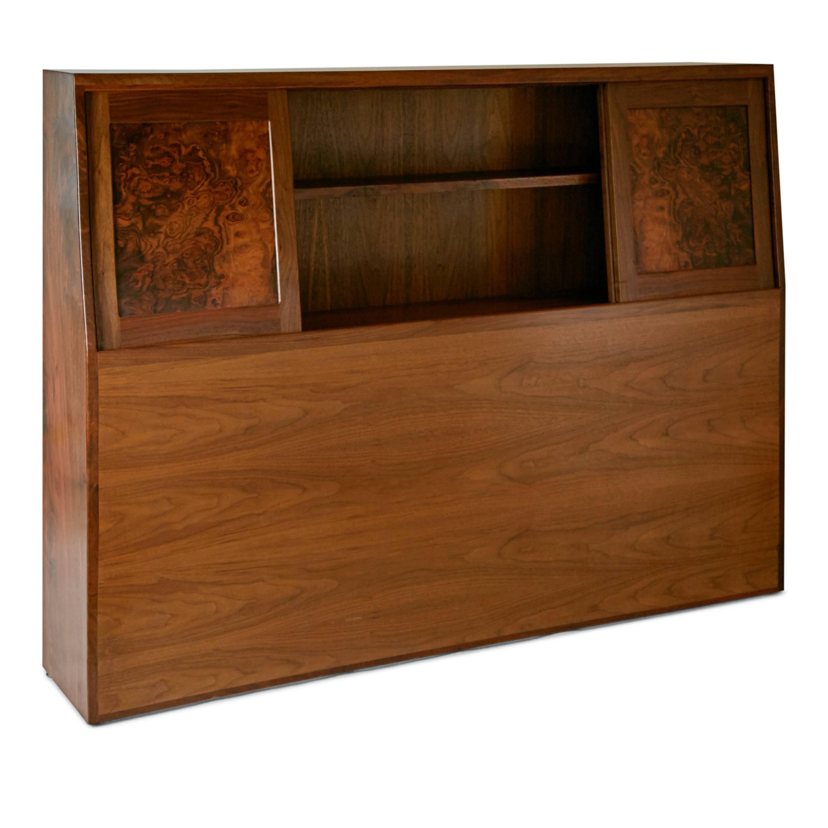 Expertly executed Queen sized headboard by craftsman Ed Crowell. This beautiful piece has been fabricated from solid walnut and features four burl wood front panels which slide to reveal a shelving unit, perfect for storing books, chargers and other