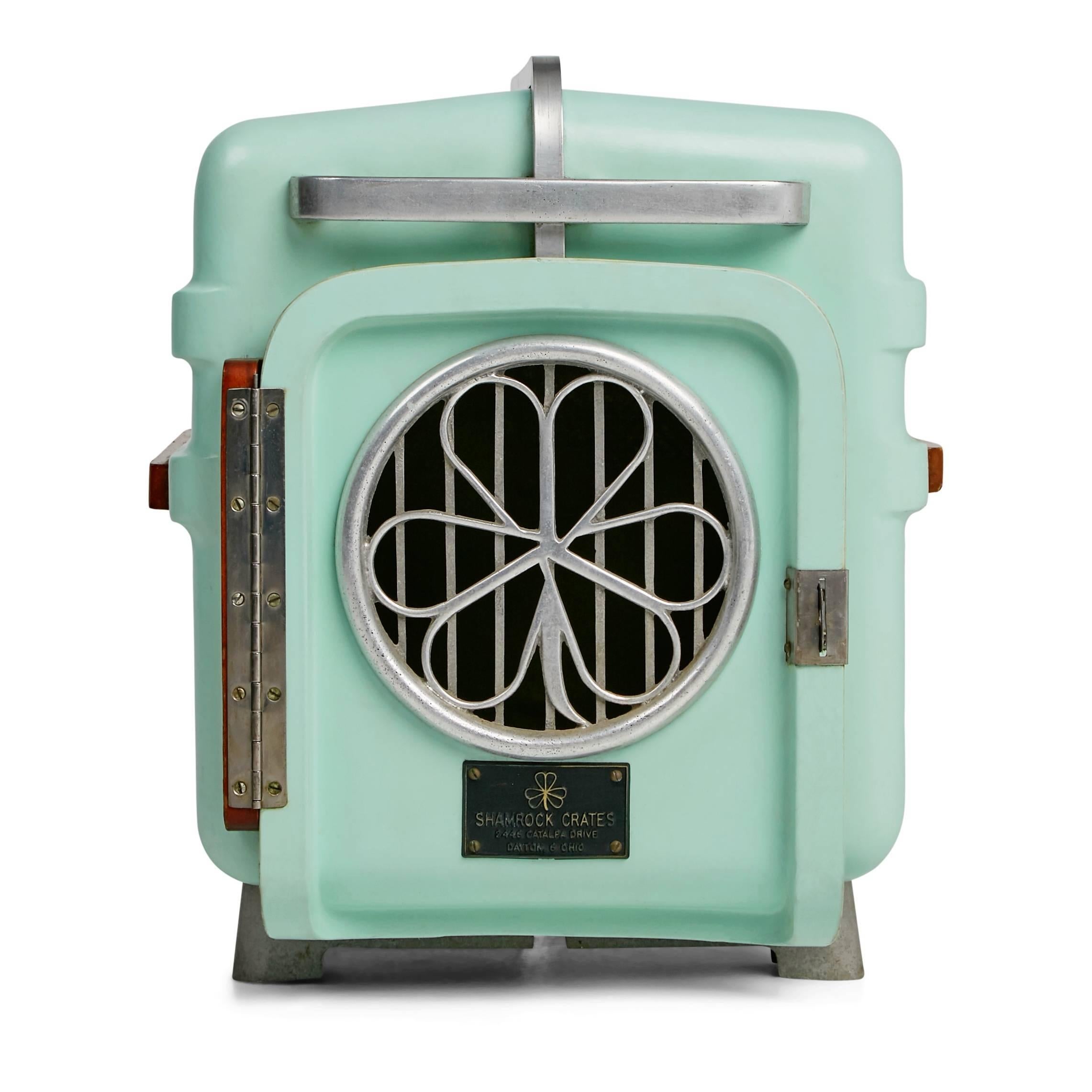 A darling vintage piece that is both practical and decorative. This fantastic mid-century modern pet carrier by Shamrock Crates features a mint pastel lacquered fiberglass shell with an aluminum base, protective band and handles both front and back