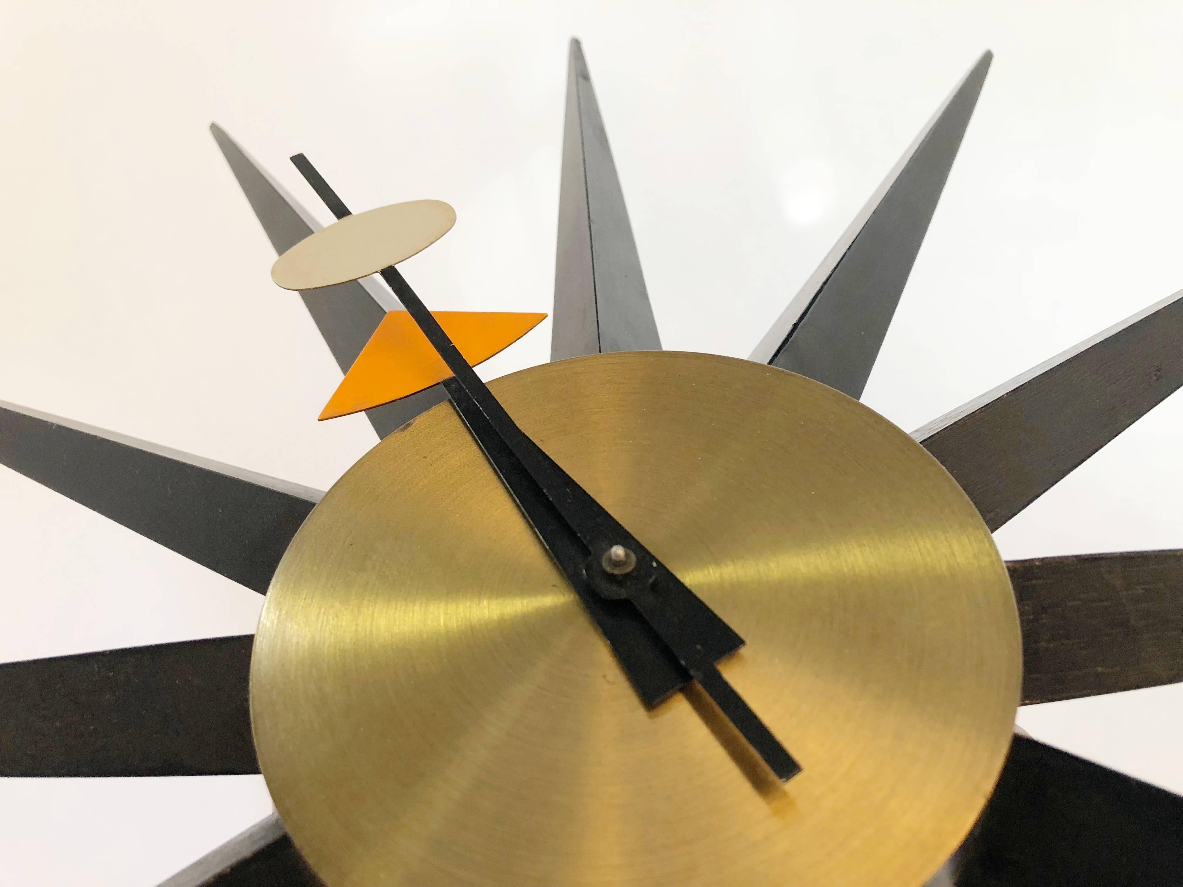 Wonderful spike Starburst clock by George Nelson for Howard Miller. Featuring black sunbeams with a brass colored clock face. The Howard Miller manufacturing label can be found on the back. 

The archetypal design makes this clock appropriate for a