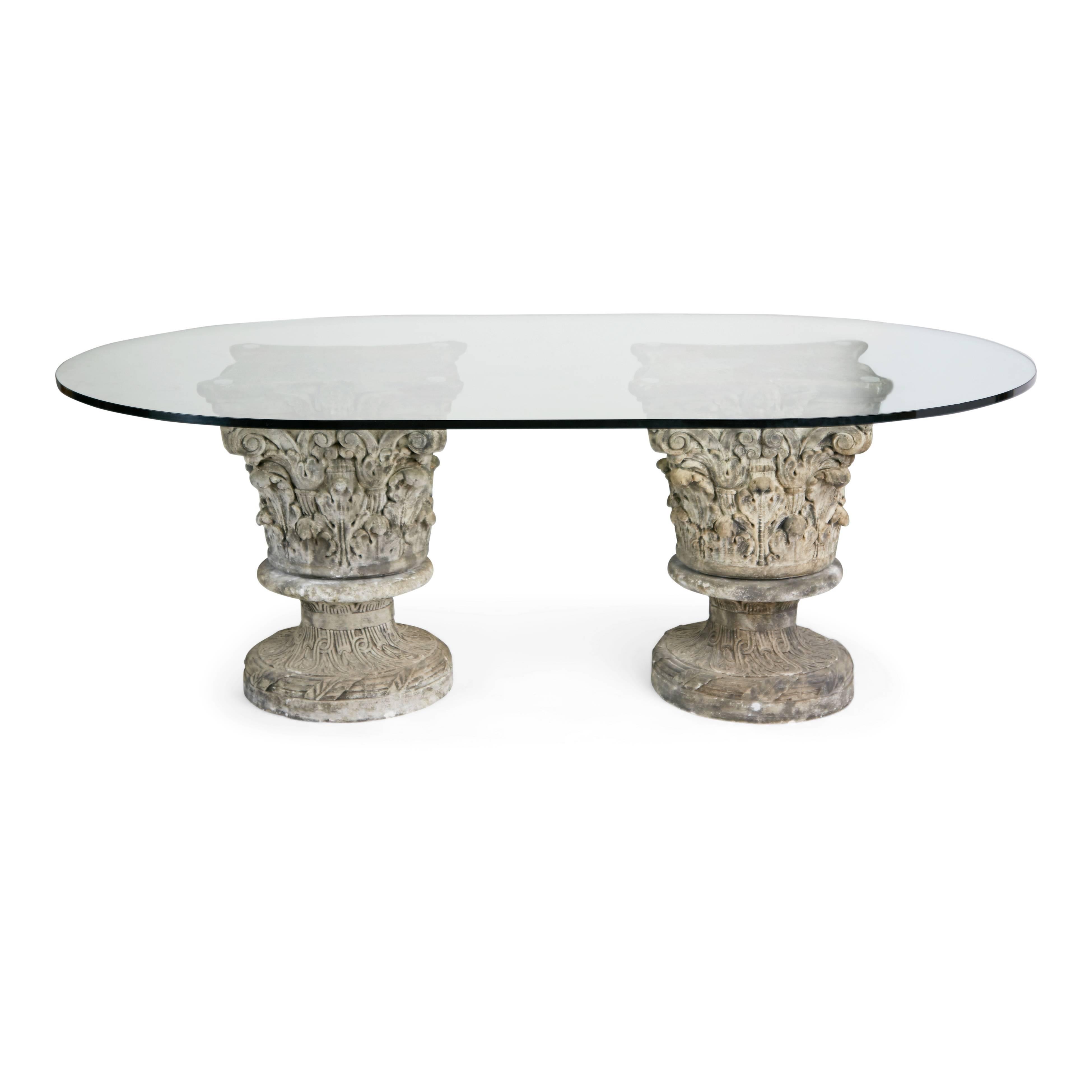 Expansive dining table suitable for indoor or outdoor use. This grand table consists of Corinthian pedestals which come in two parts and are stacked on top of one another to achieve a sturdy base for supporting a substantial glass top. The pedestals