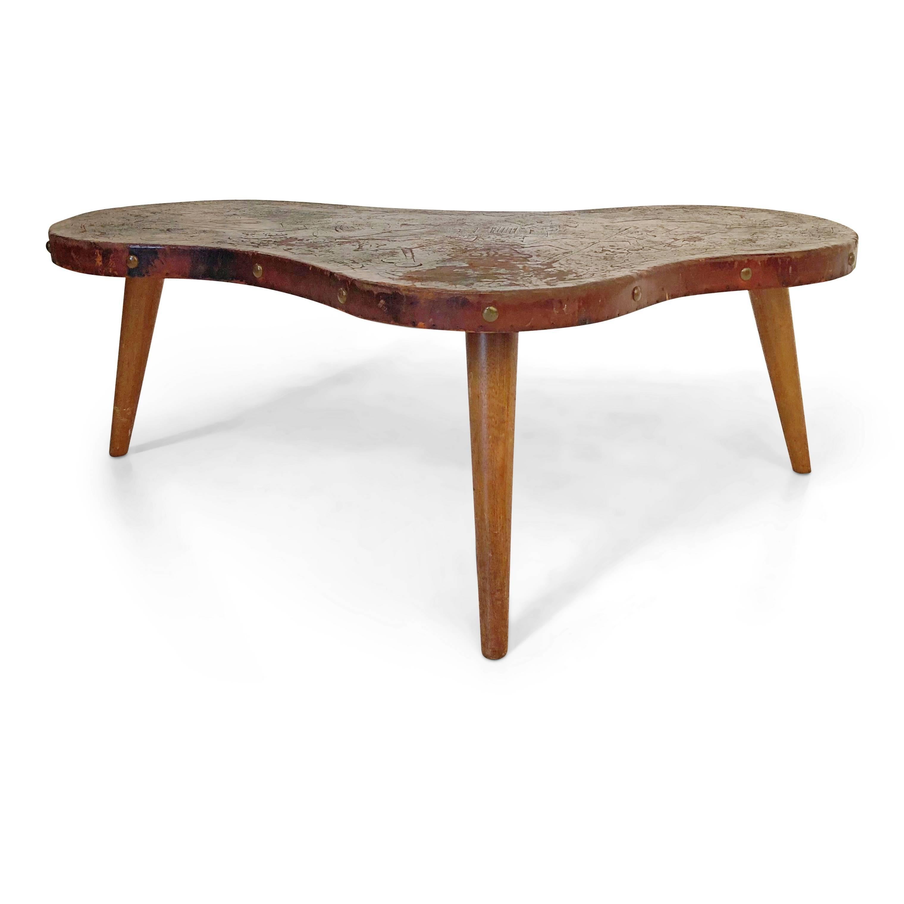 *NOTE* For all items from this dealer, please click VIEW ALL FROM SELLER below on this page.

Beautiful wrapped leather Peruvian coffee table which has been skilfully decorated with hand tooled primitive South American motifs. This abstract