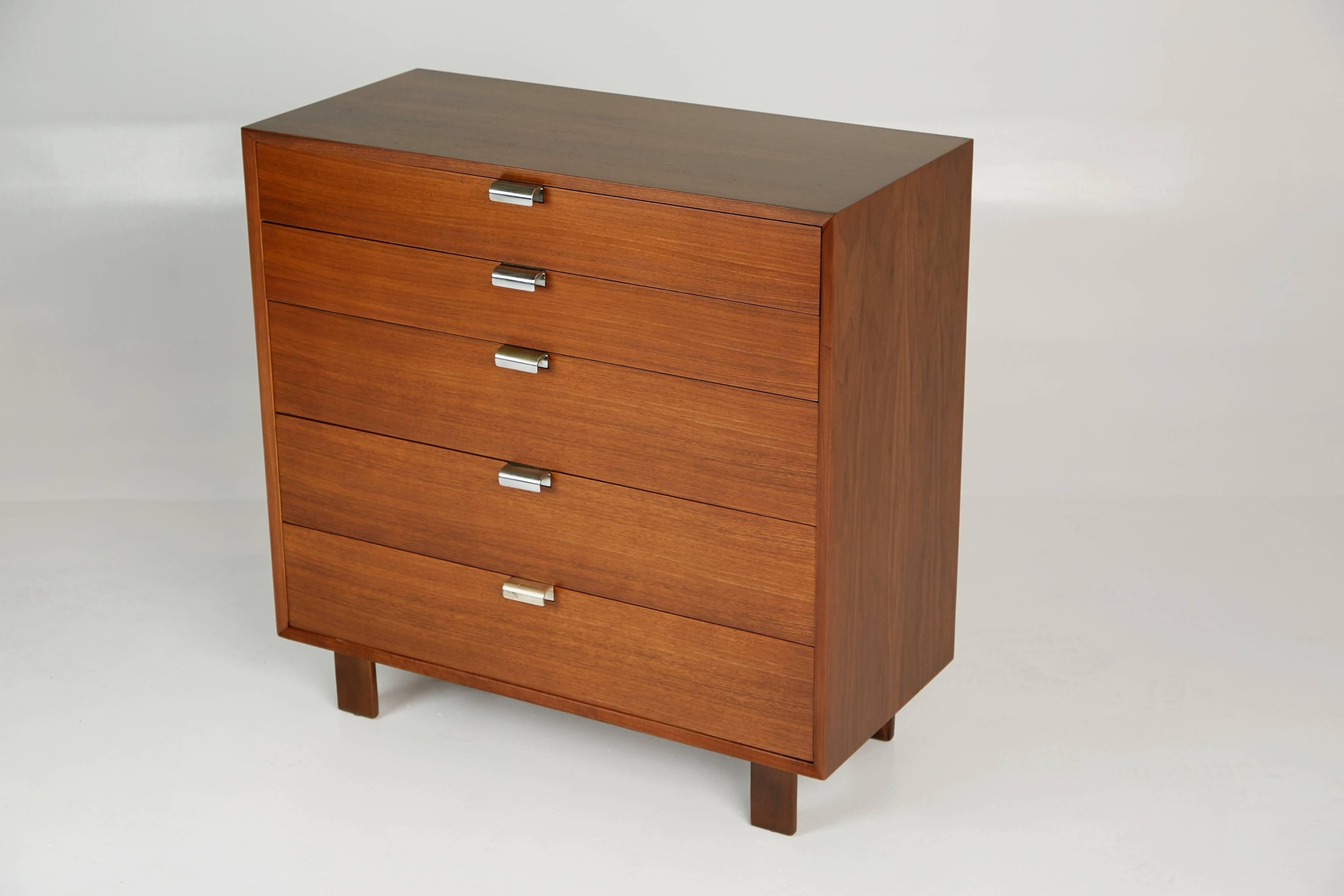 Designed by George Nelson, this highboy dresser was part of Herman Miller's collection of modular basic storage components. The chest has been newly refinished and features beautiful wood grain which displays fluid movement and variation in tone.