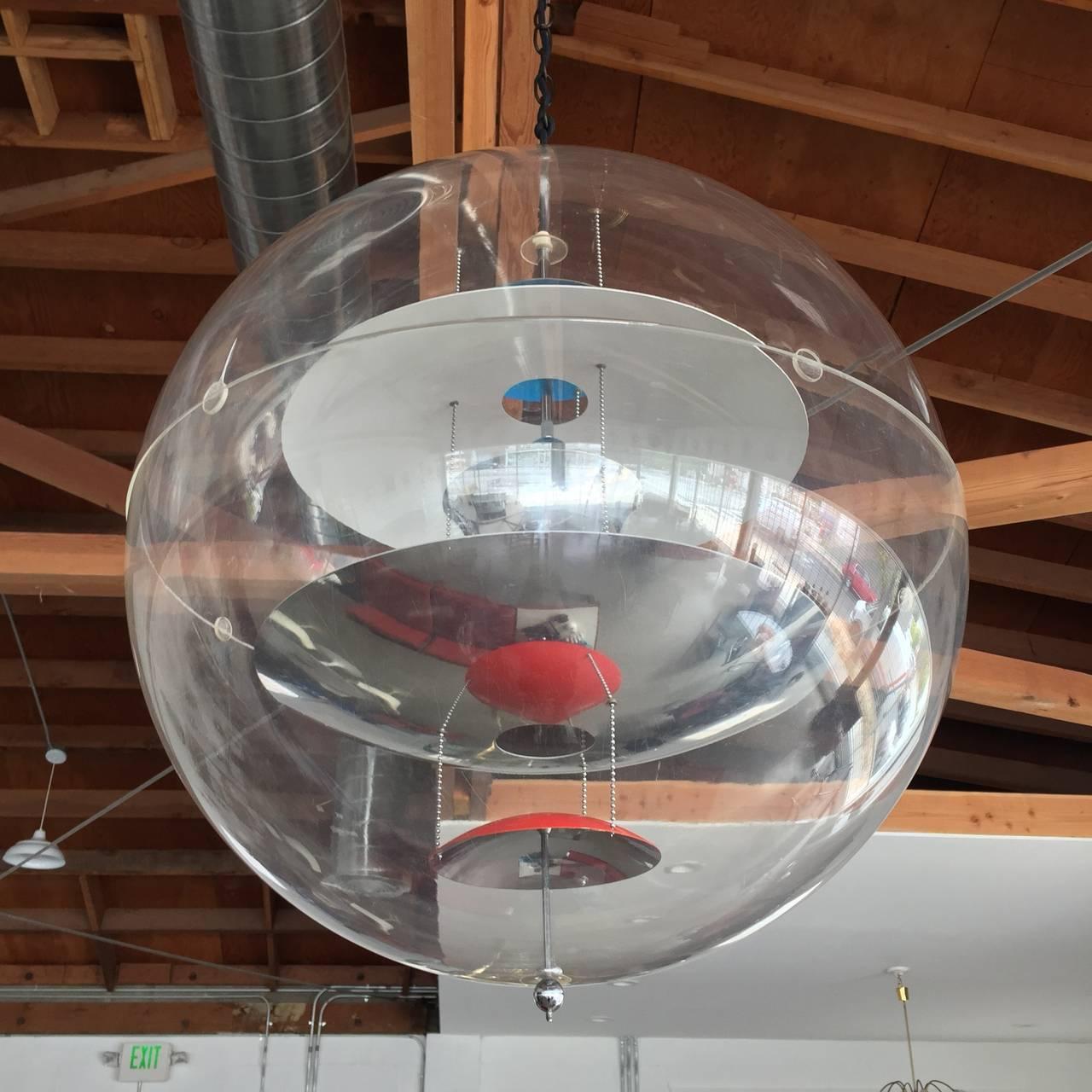 A 1969 original large production of the iconic and inimitable design by Verner Panton for Louis Poulsen. This acrylic globe encompasses five curved reflectors suspended through the center - three chrome, one red, the other blue. With Panton's