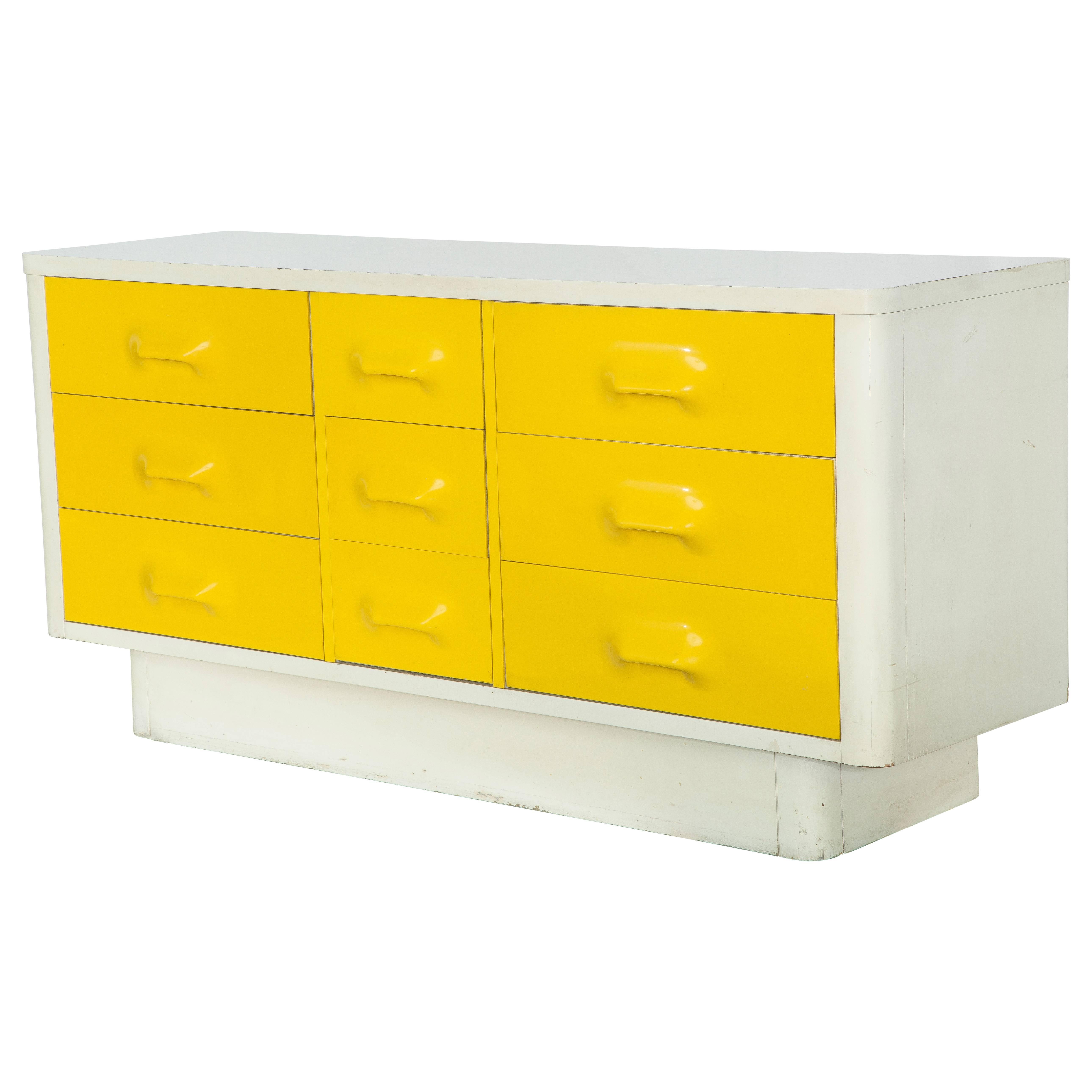White and yellow Broyhill "Chapter One" dresser in the style of Raymond Loewy Mod-Pop Industrial Design, circa 1970s. The white body of the credenza is white formica laminate, and the vibrant yellow drawers are molded plastic. Nine drawers