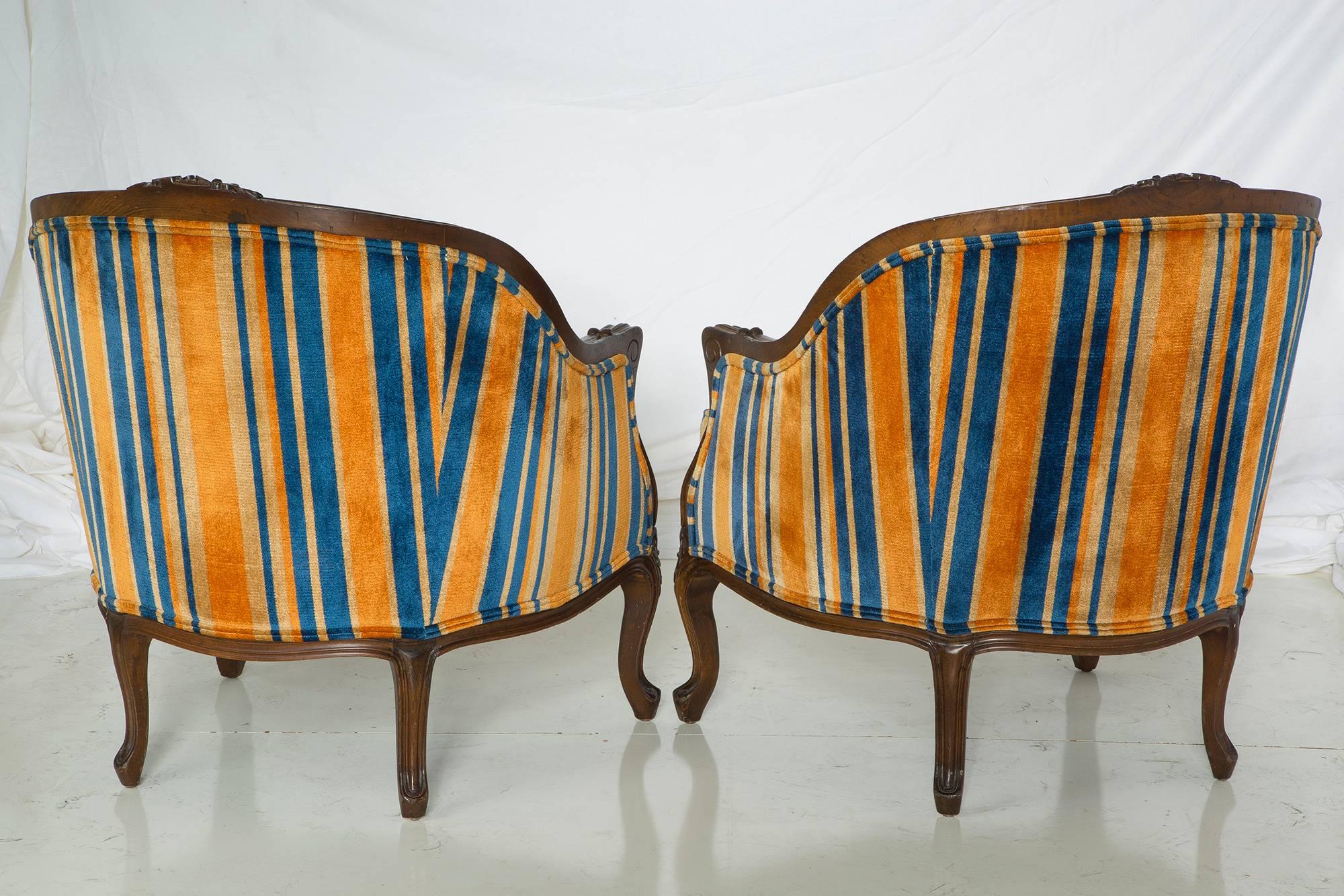 This pair of amazing 1940s salon lounge chairs is in truly remarkable condition, and so stylish and funky! The striped velvet upholstery is framed by the ornately carved walnut details.