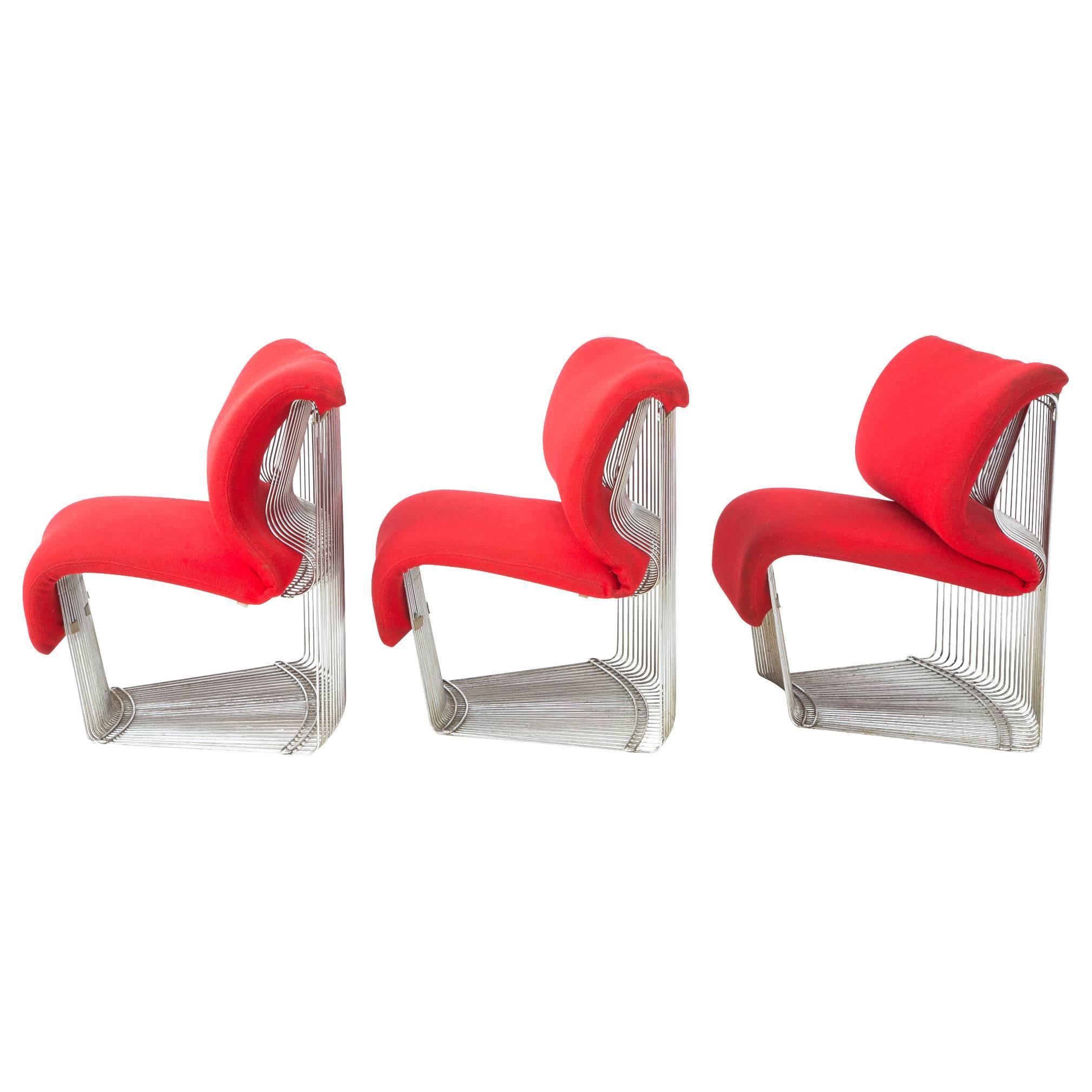 This iconic set of three chairs and ottoman was designed by Verner Panton for the exquisite Varna restaurant of Arhus, DK in 1971. Apple red upholstery on the chairs is removable by velcro. Ottoman does not come upholstered. Chrome-plated steel rods