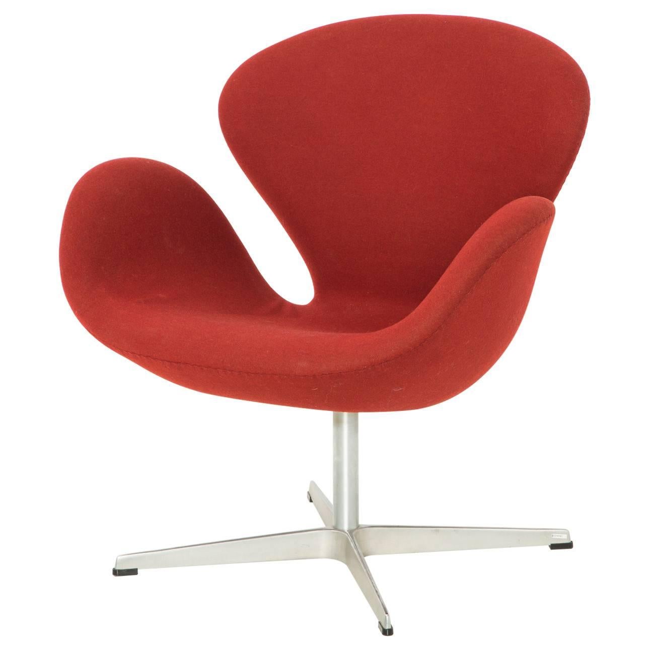 Iconic swan chair by Arne Jacobsen for Fritz Hansen, designed in 1958. Seat upholstered in red fabric on an aluminum base. 

Foam, frame and fabric are in good condition. Fritz Hansen labels underneath seat.  


