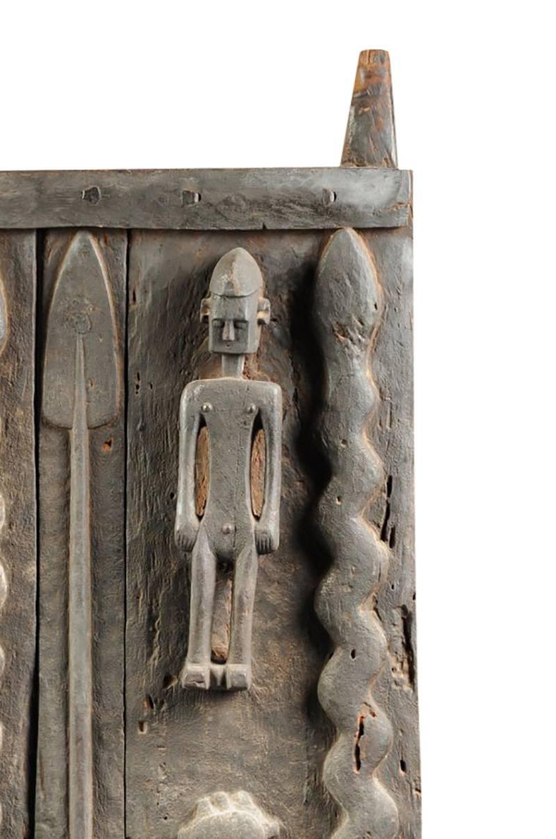 A large and important artifact, this hardwood and hand-carved African tribal granary door measures approximately 65