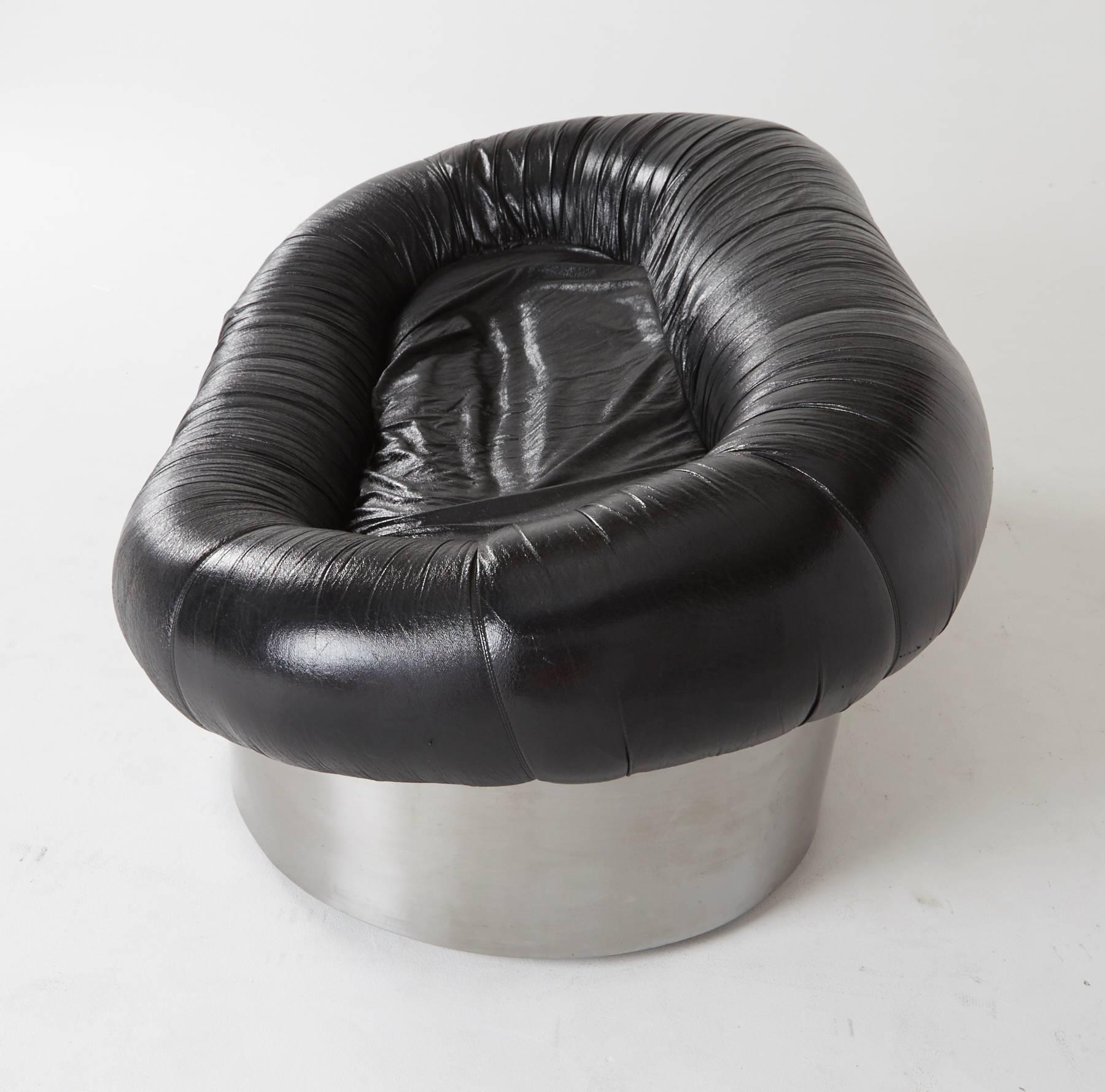 An extraordinary sofa by acclaimed Italian designer Antonello Mosca. Mounted on a stainless steel base, the black leatherette loveseat is comfortably encased by a tubular cushion. Of the biomorphic mid to Postmodern era, this supremely cool sofa