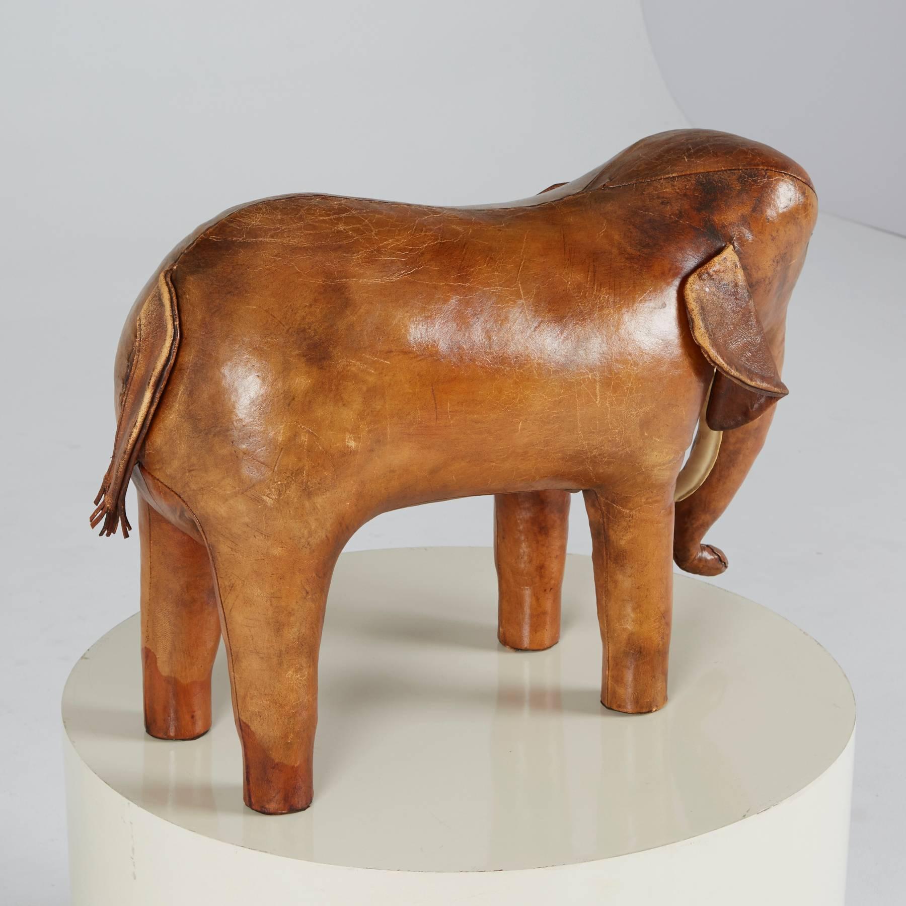 A phenomenal example in tan leather, this large elephant ottoman / footstool by Dimitri Omersa for Abercrombie and Fitch was made in the 1960s. For collectors and interior designers, the leather on this one is exquisite. Incredible color and patina.
