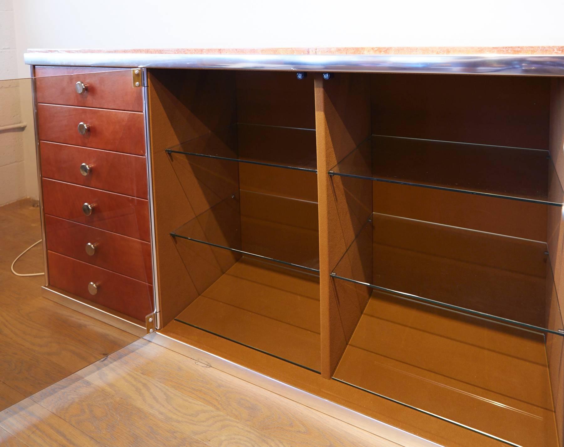 A stunning and swank design, crafted by Guido Faleschini for Mariani circa 1970 for Pace. This credenza features plenty of storage space, including two glass shelves and six smaller drawers. The exterior side panels are constructed of a fine