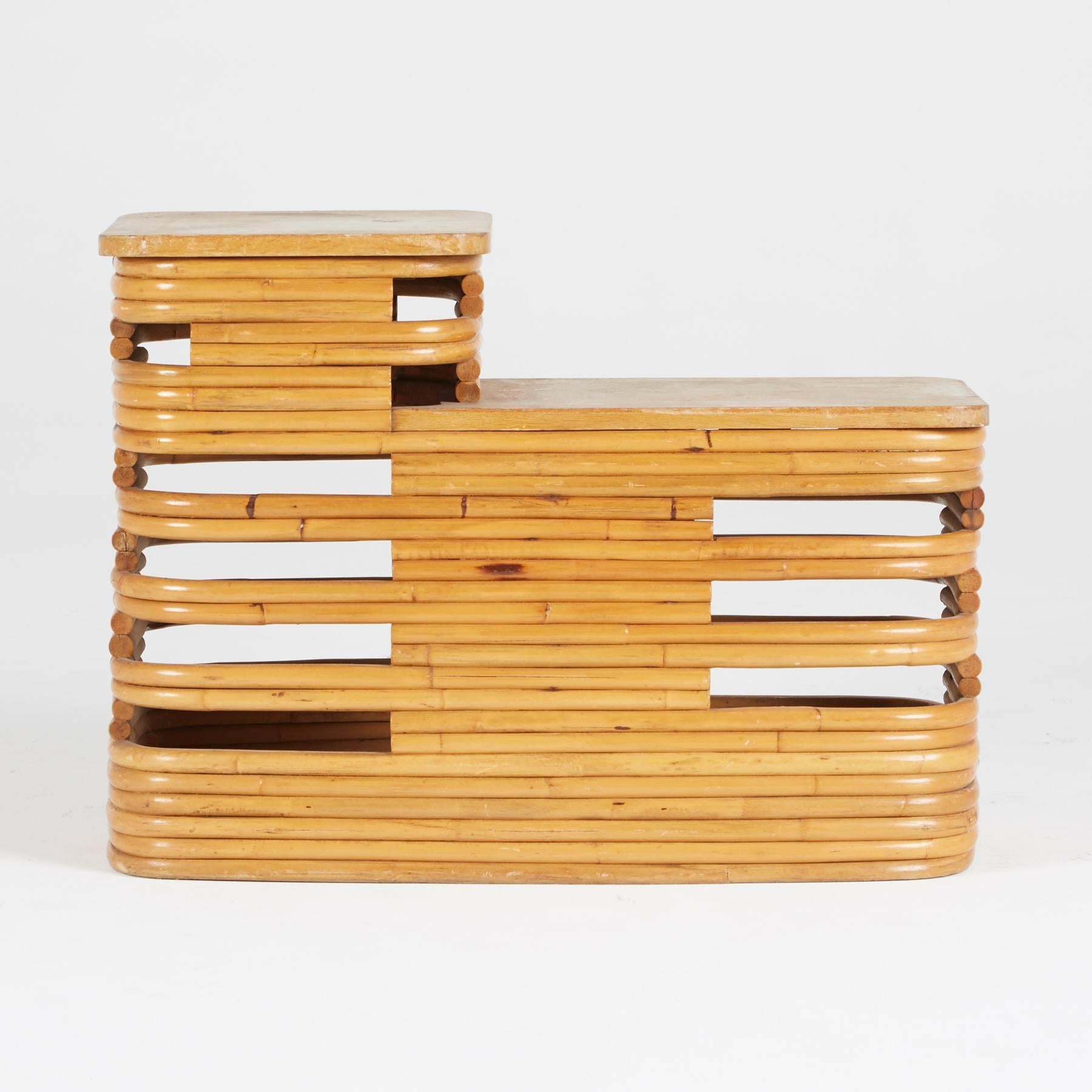 Created by Paul Frankl, 1940s. Constructed of stacked rattan, this two-tiered table can be used as an end table, side table or nightstand. The light, rich color of the wood and rustic yet rounded design makes this piece perfect to style with Art