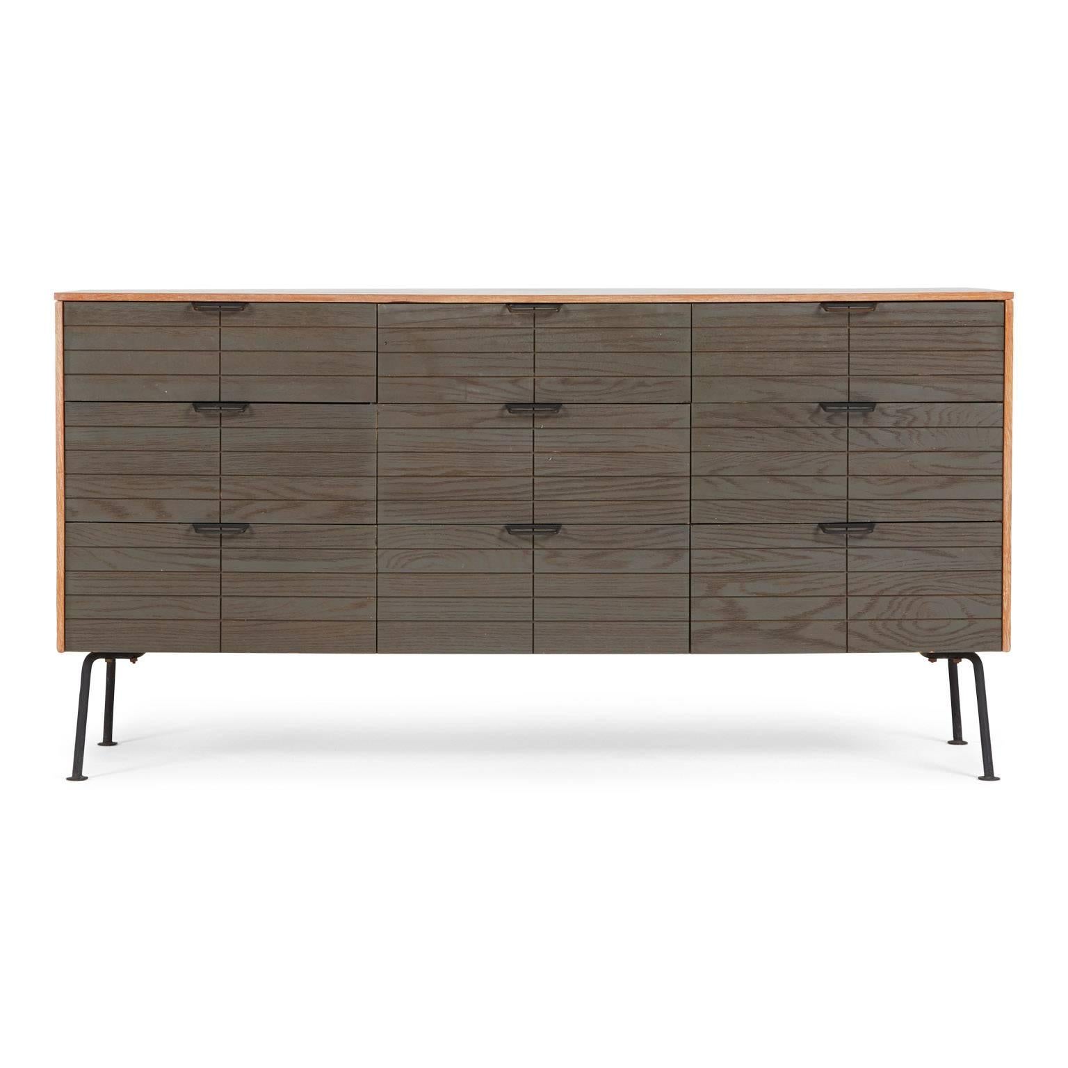 A desirable and rare five piece set by Raymond Loewy for Mengel, comprised of a drop-front secretary with three long drawers, a low nine-drawer dresser with a lift-out mirror, a single-drawer bedside table, a leatherette-upholstered stool and a