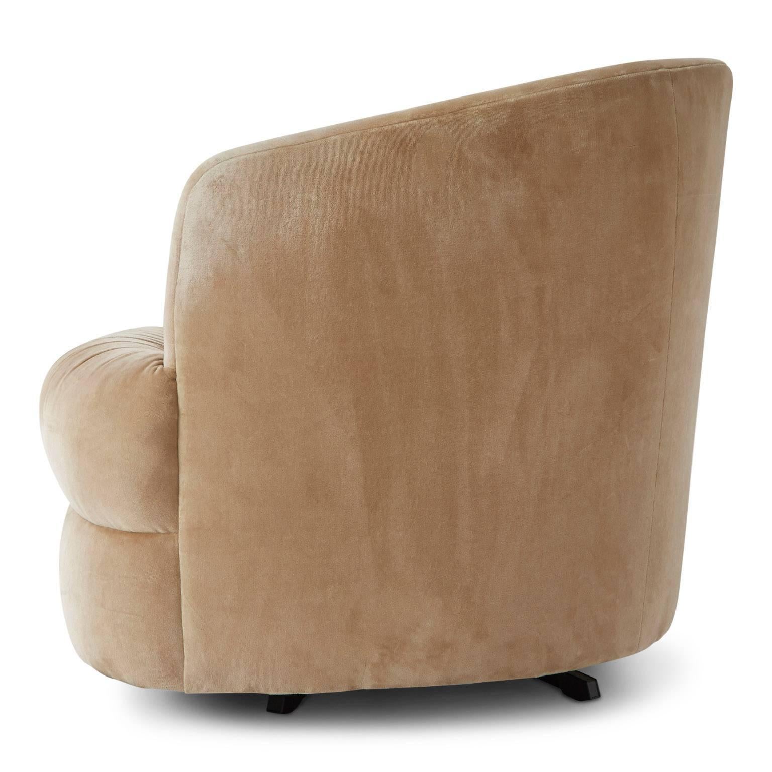 Attributed to Steve Chase, this Milo Baughman style swivel barrel chair upholstered in a stylish, neutral shade of buff velvet with elegant ruche details, on a black pronged base. This Mid-Century Modern piece could be utilized as a lounge, club,