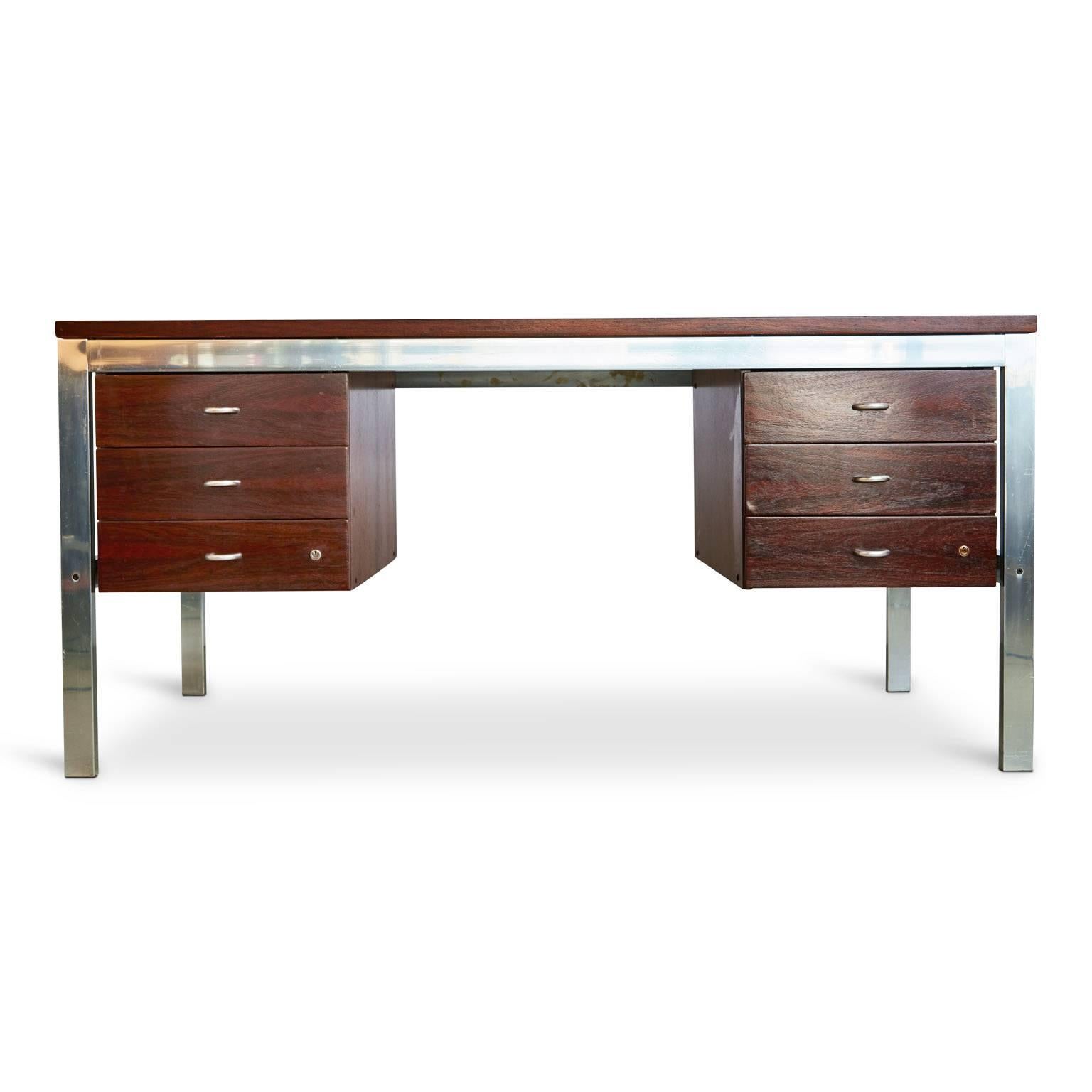 Recently refinished Brazilian rosewood desk with aluminum frame by Tora Brazil. Featuring double pedestals consisting of two (2) sets of three (3) drawers with half-circle chrome pulls and the original label on one end with the word 