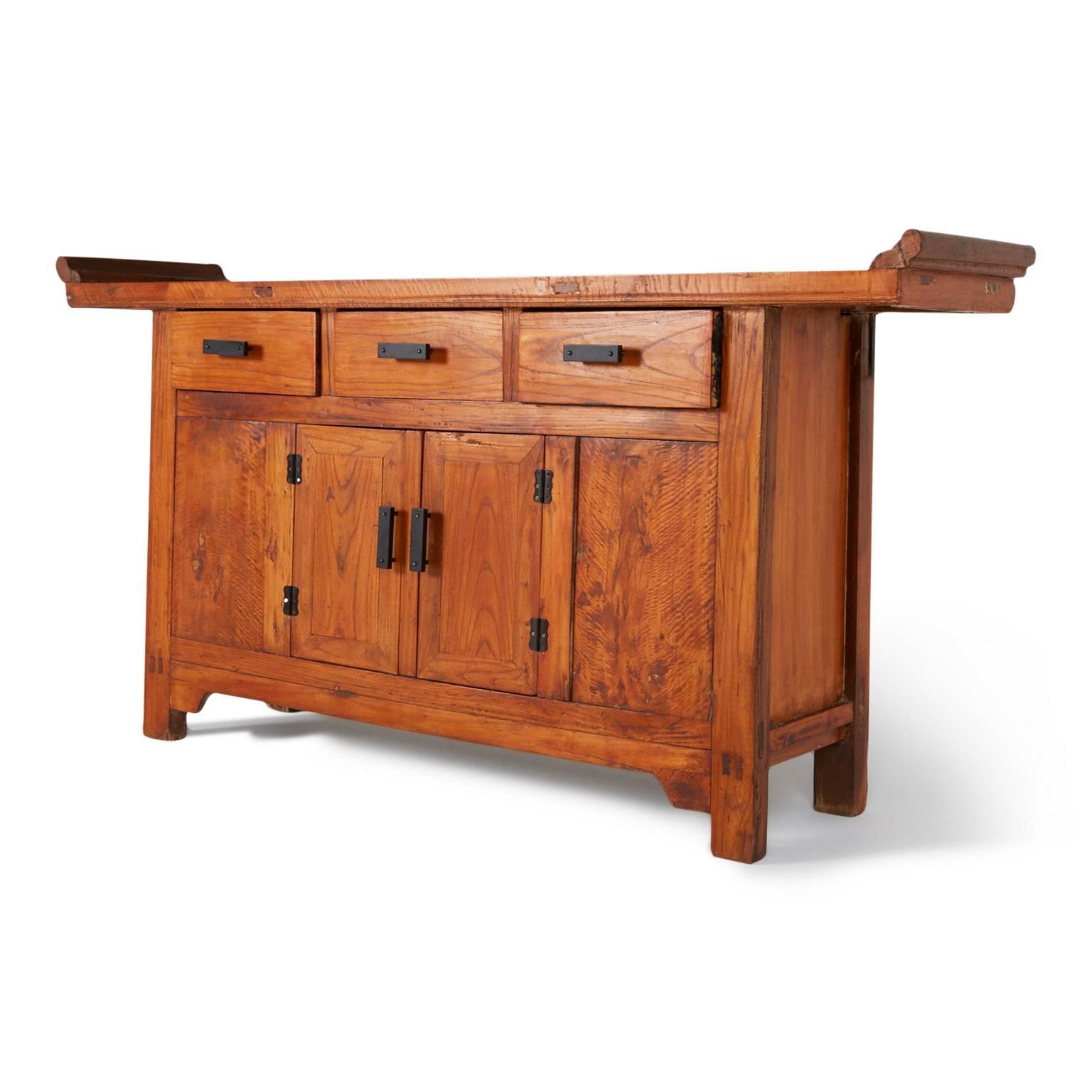 Taking inspiration from the Chinese Shan Xi altar cabinet, this credenza displays elements of North China's traditional cultural style. Comprised from exotic Camphor wood with beautiful grain and including the original black antique hardware. The