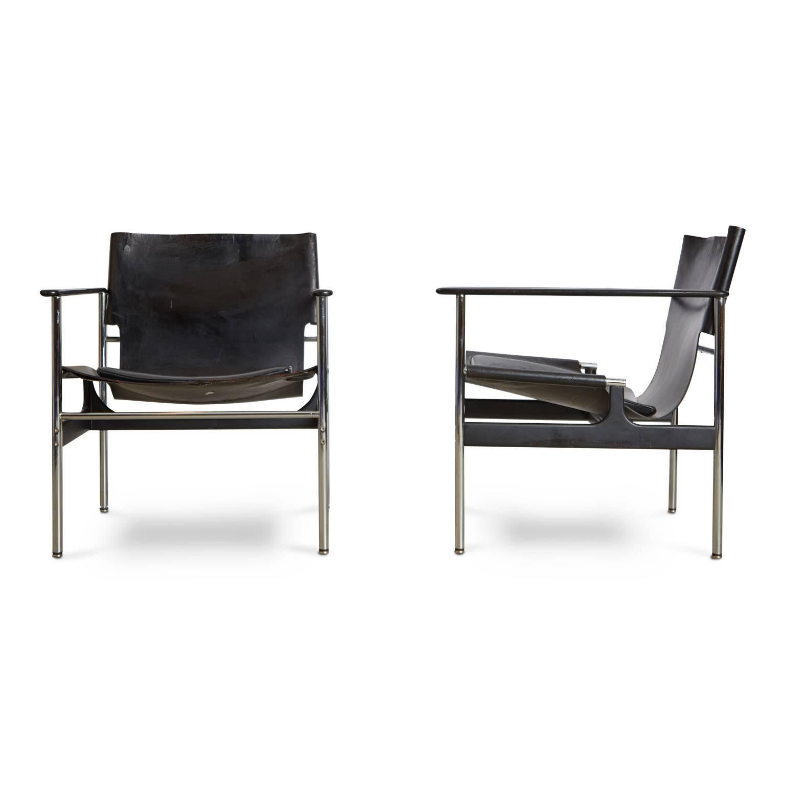 Designed by Charles Pollock for Knoll International, this pair of Model 657 black leather sling lounge chairs (circa 1960s) perfectly blend comfort, functionality and style. The spare frame comprises of polished chrome steel tubing and cast