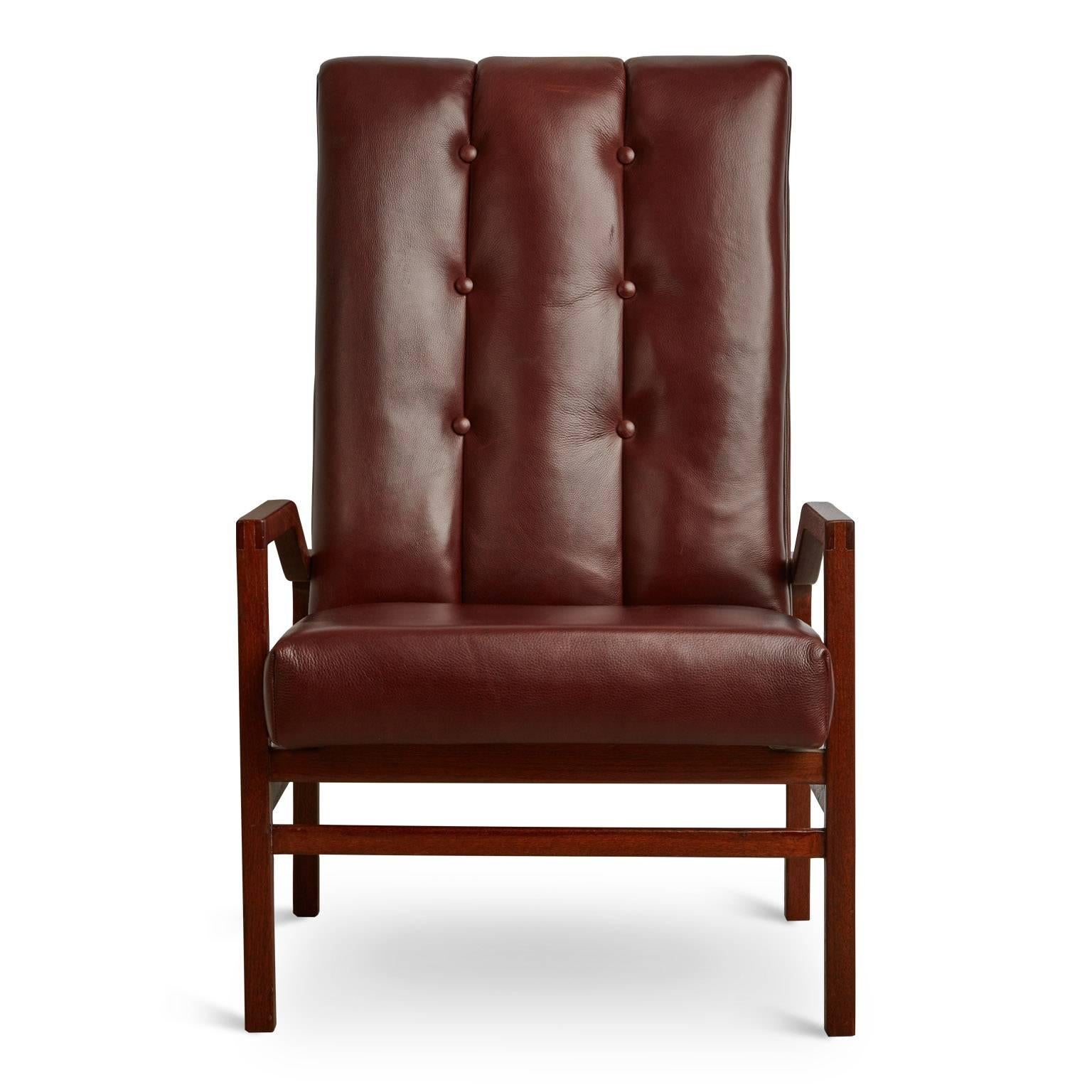 Pair of recently restored Danish Modern high back armchairs. Comprised of a newly refinished solid teak frame and recently reupholstered button tufted high-back seats in a full grain burgundy leather.

These elegant side chairs would be ideal for a