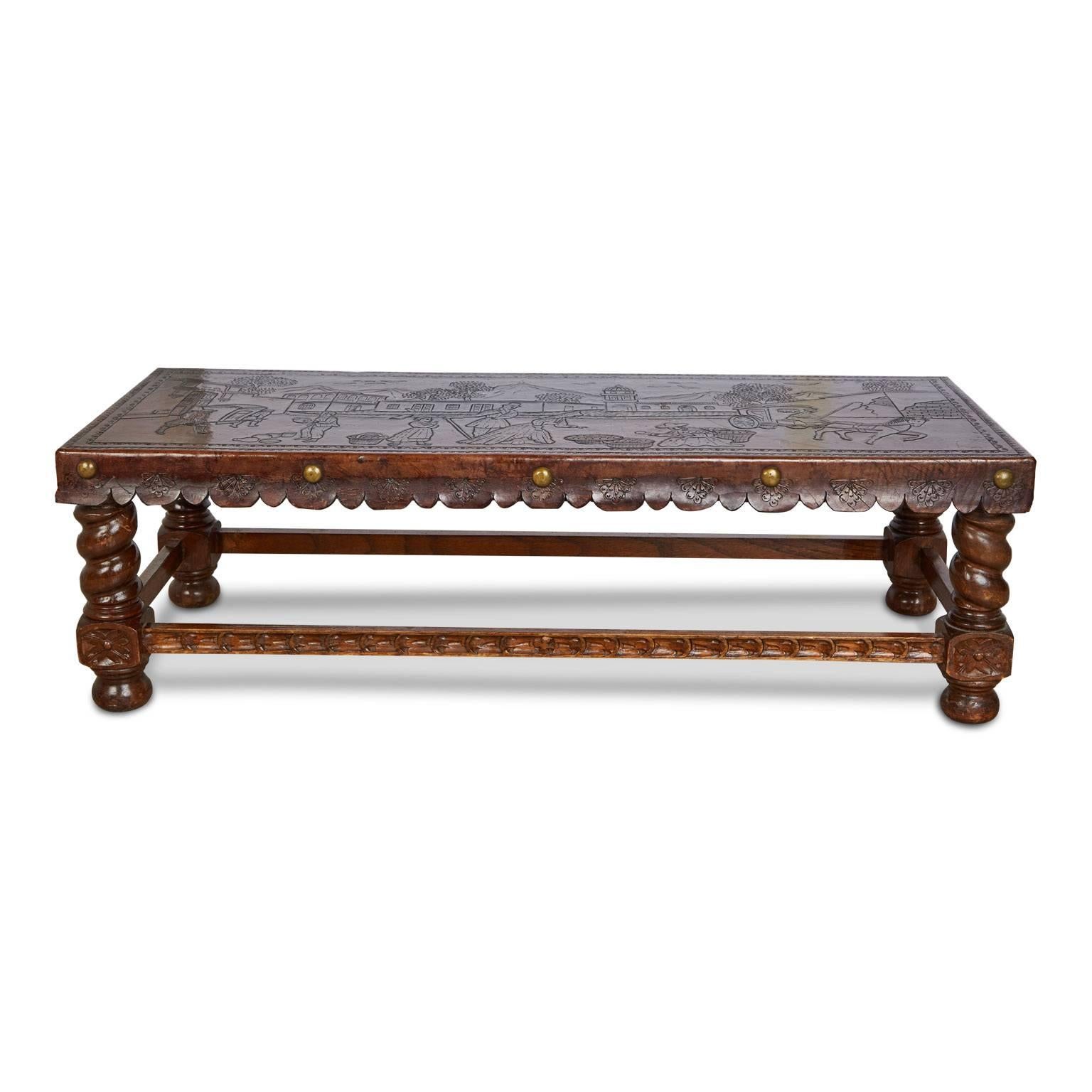 Beautifully crafted hand tooled bench or coffee table (can be used for either) depicting a colonial missionary Scene. Fabricated from a walnut frame and turned wood legs with carved details. The top is wrapped in a deep toned leather with a