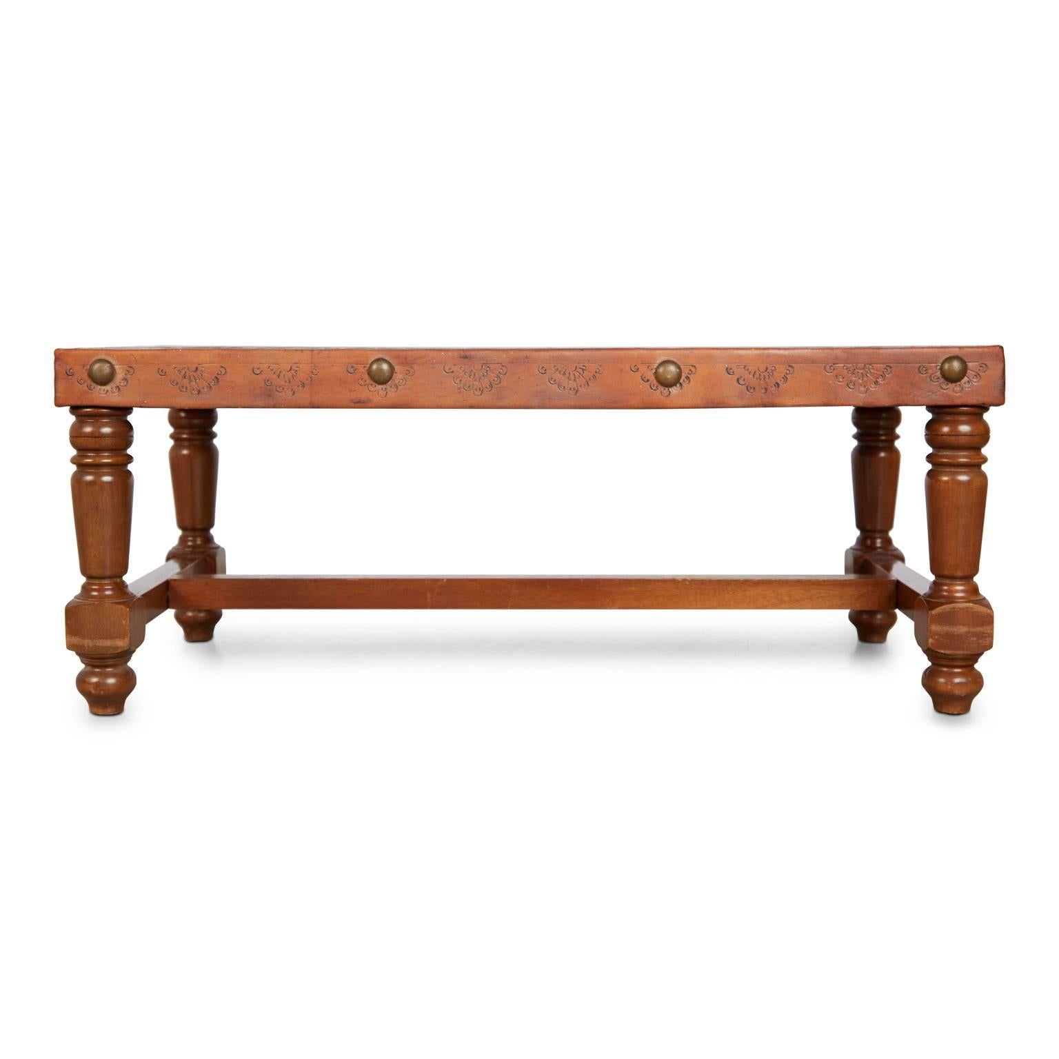 Beautiful hand tooled Peruvian bench or coffee table (you can use for either) depicting a South American pastoral scene. Fabricated from a walnut frame with turned wood legs, the top is wrapped in leather and illustrated with embossed figures on a
