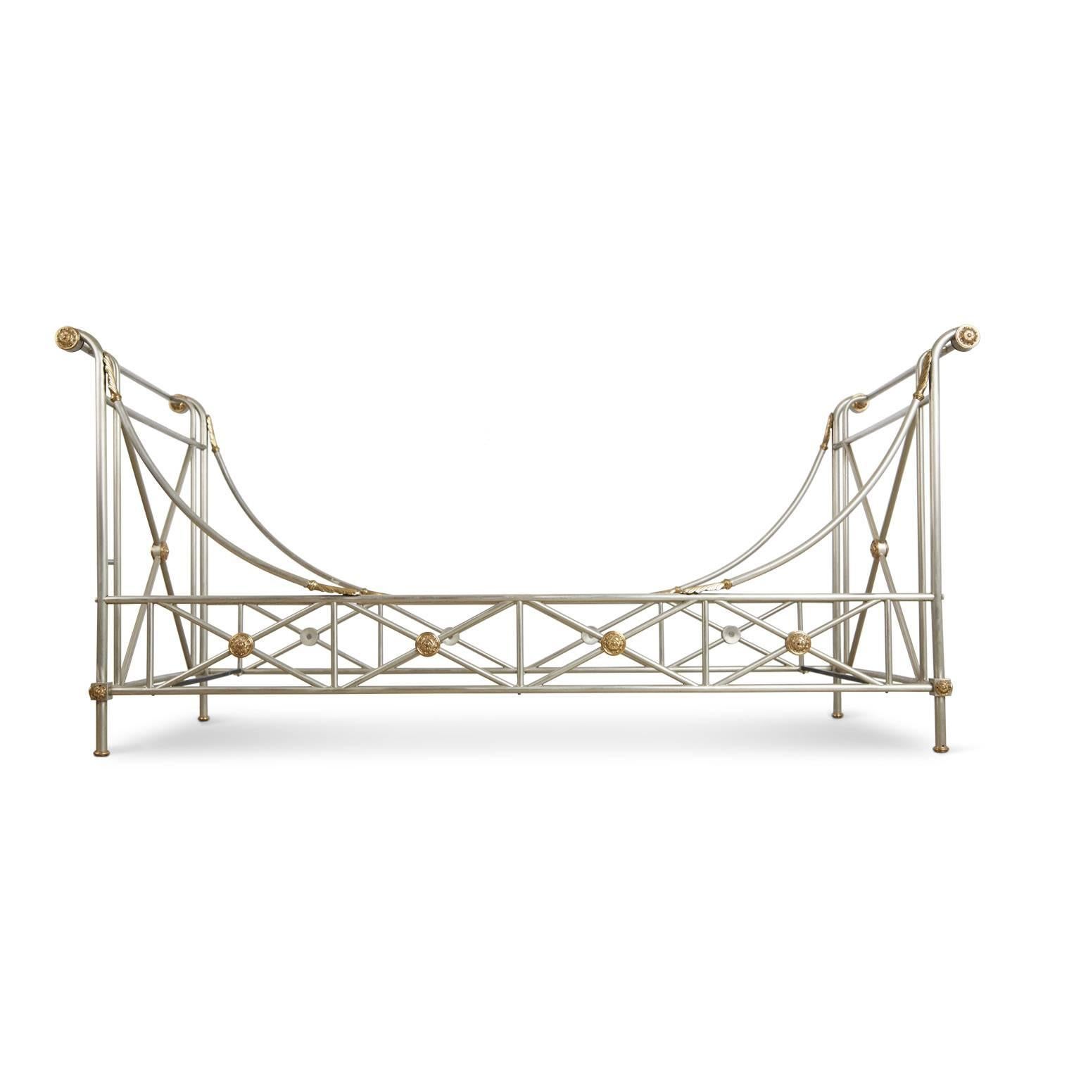 Gleaming Maison Jansen brushed nickel daybed with beautiful brass accents. Featuring an elegantly constructed frame with swooping side rails and elevated identical head and foot boards and punctuated with brass medallions as well as arched acanthus