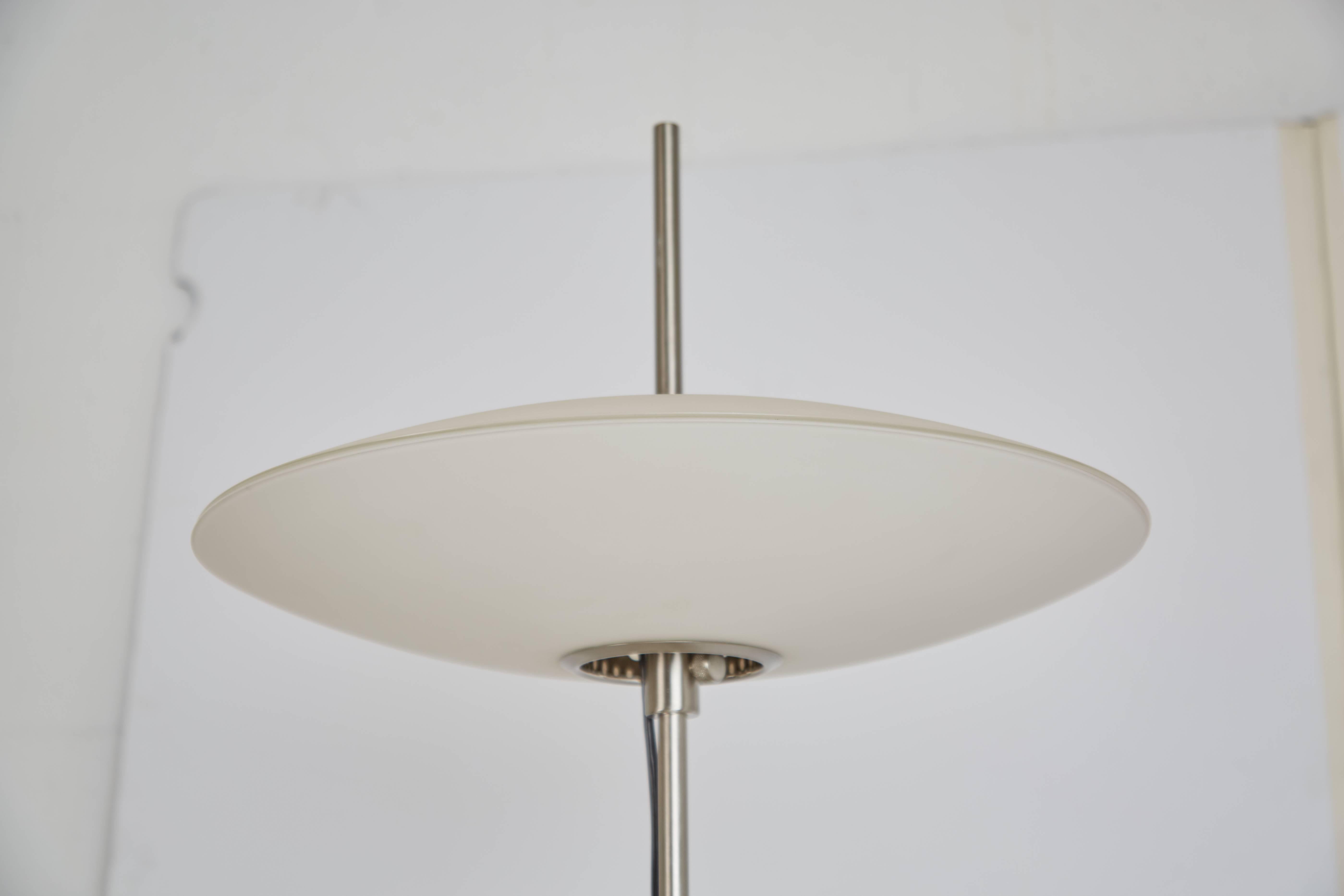 Looking to add a little pop of Googie style to your interior? This streamlined standing lamp will do just the trick. Comprised of an aluminum stand, concaved four prong base and topped with a frosted glass flying saucer shade. 

This adaptable