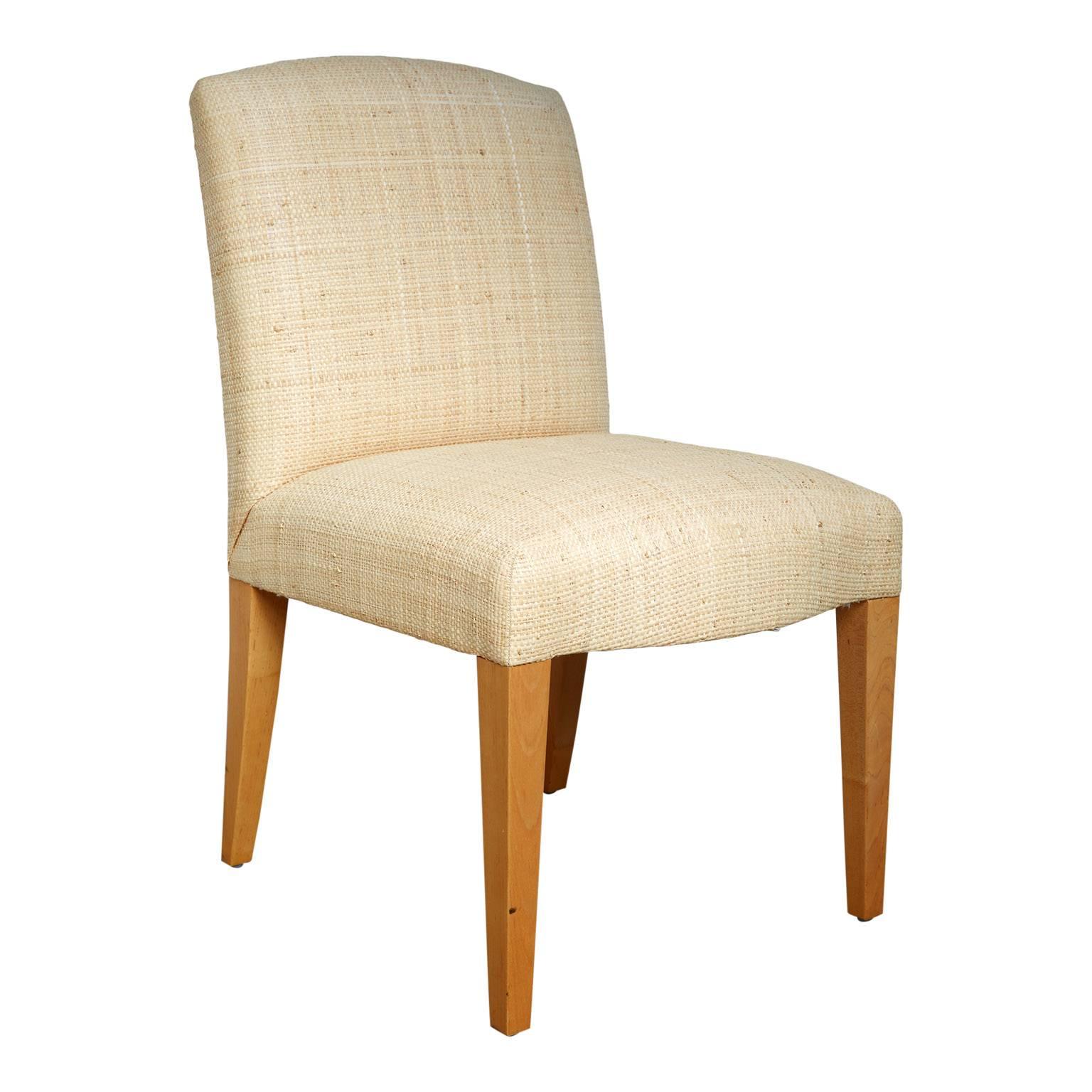 Set of four custom order Plaza chairs from Donghia. The set is made up of four side chairs that have been custom upholstered in woven bleached grasscloth. The wood has been finished with a natural stain. Comes with original receipt which has the