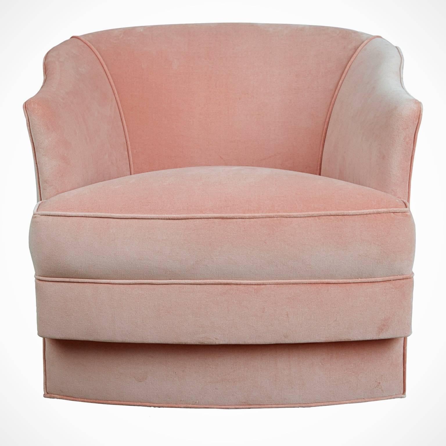 Sumptuous set of four swivel tub chairs by John Stuart. Newly upholstered in a cotton velvet in a delicate shade of pink coral and set on moveable casters for ease of relocation and use. They would look wonderful paired with a Lucite or marble